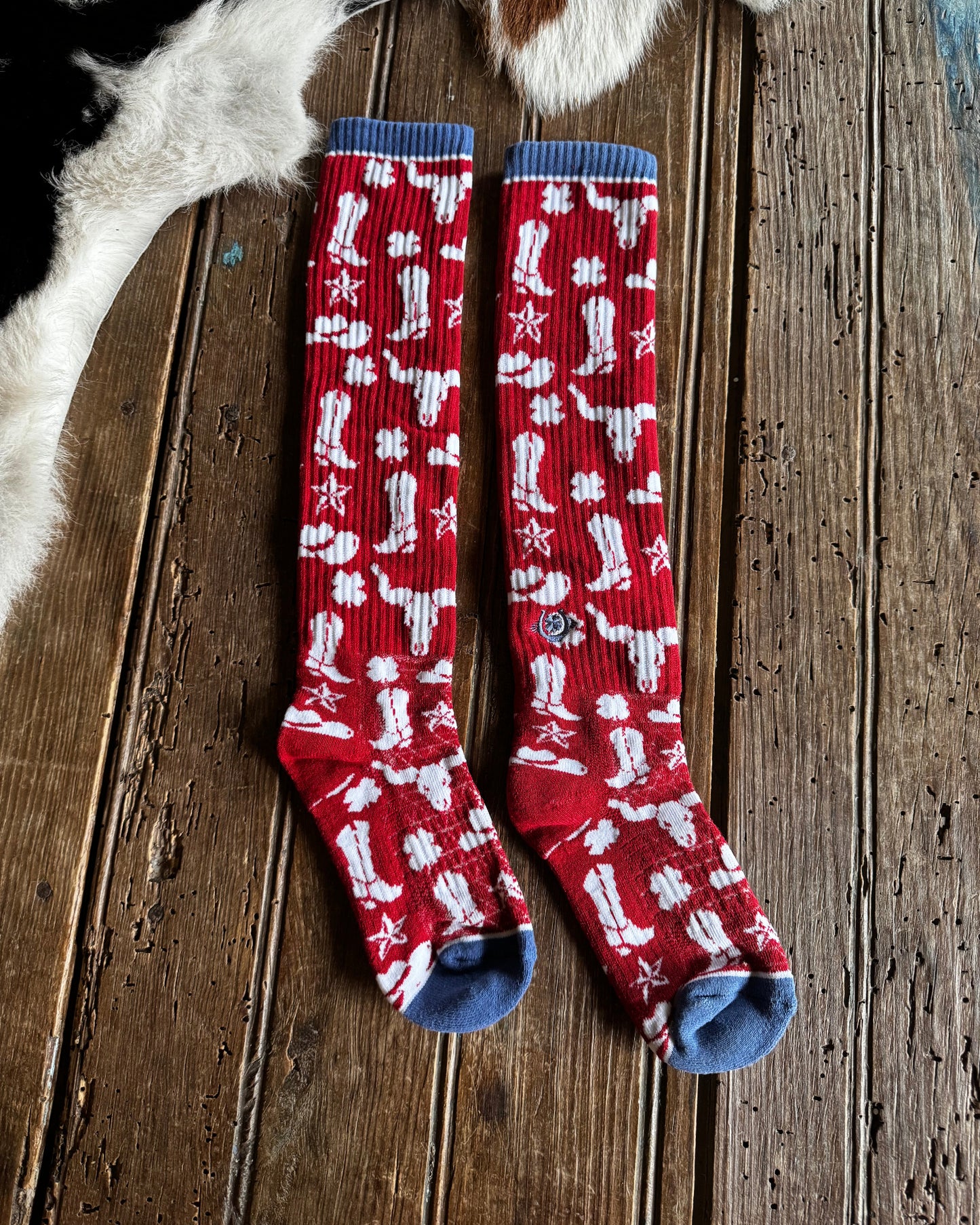 Red socks with white patterns on a wooden surface