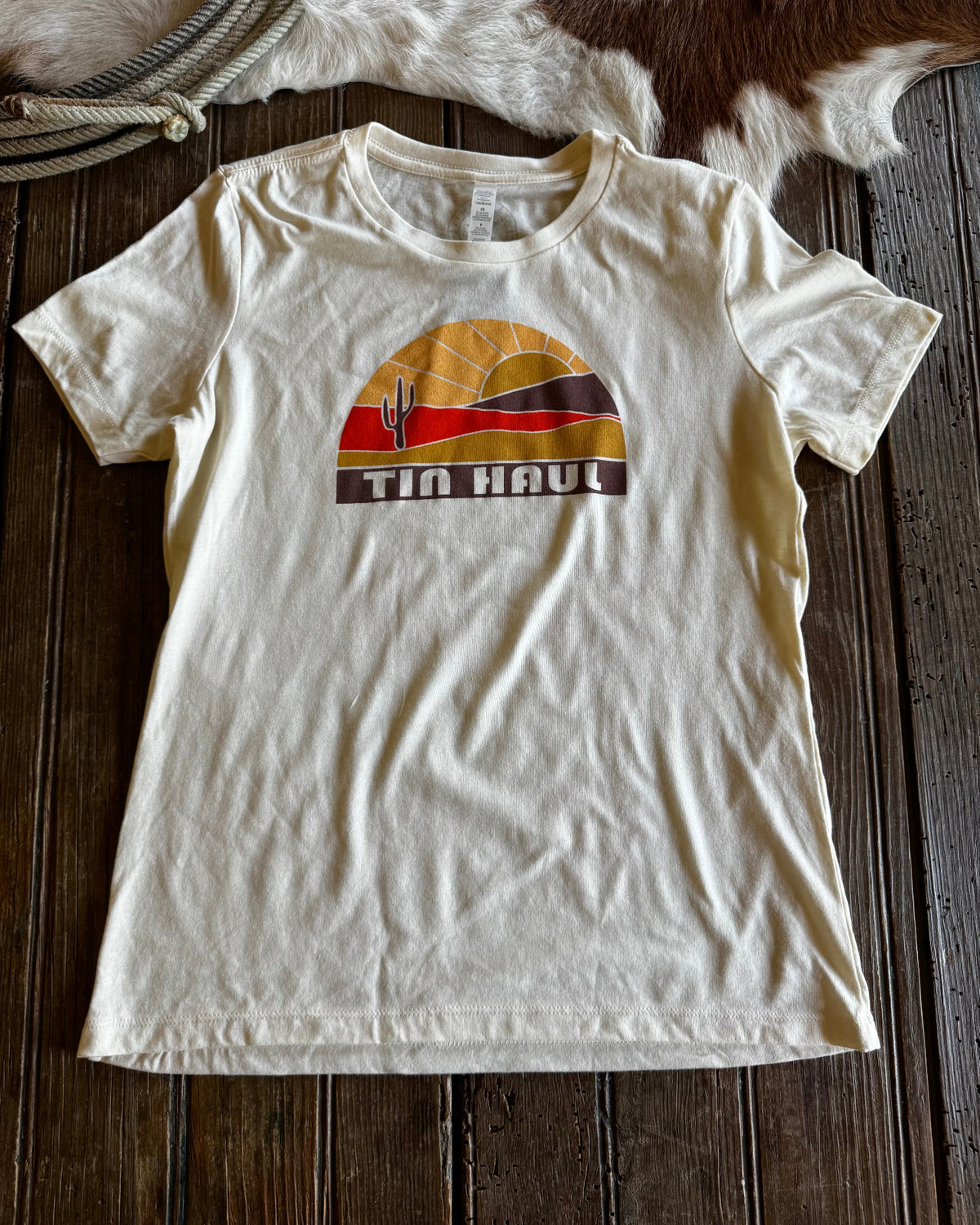 White t-shirt with a graphic design on a wooden surface