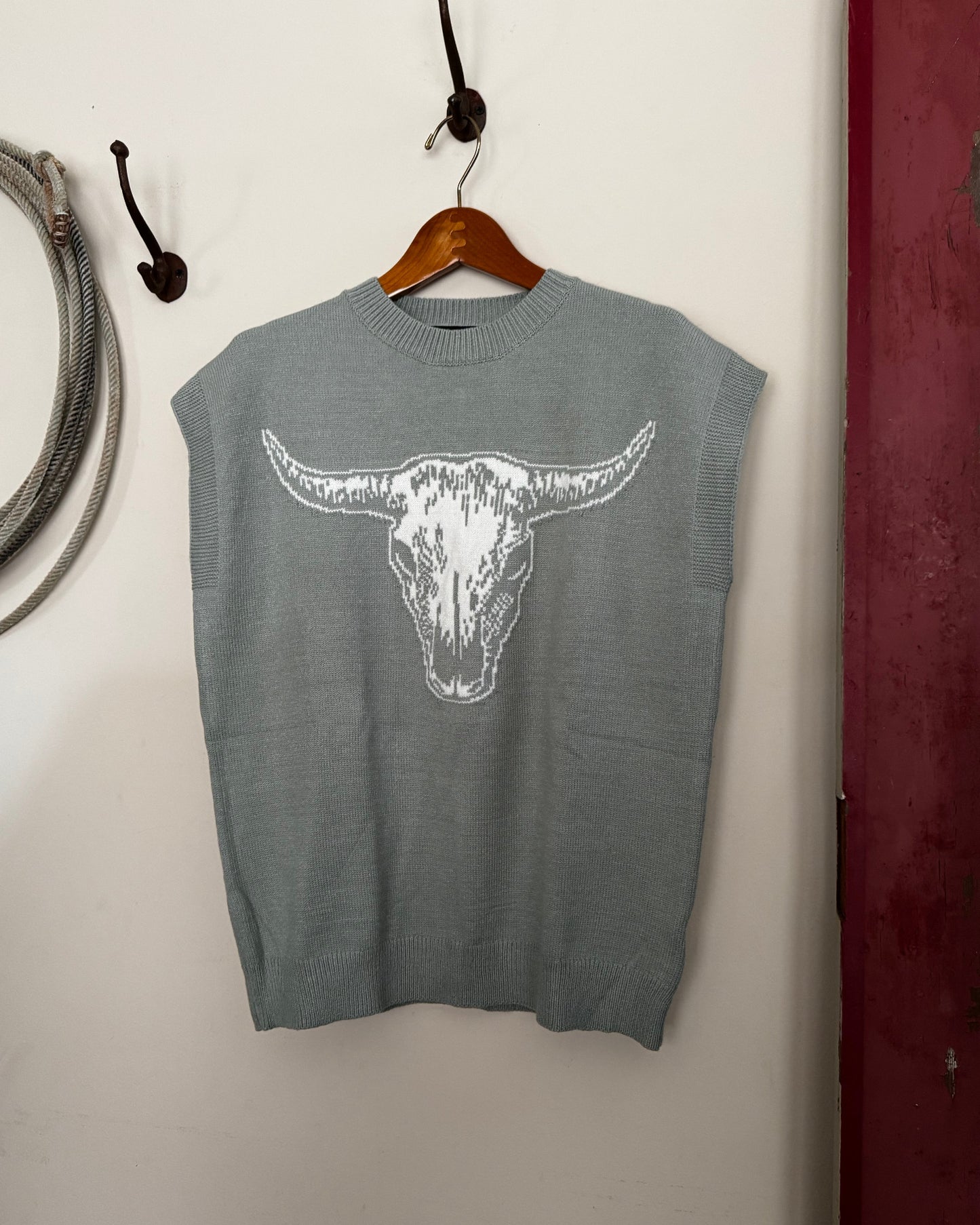 Green sweater with a white graphic on a white surface