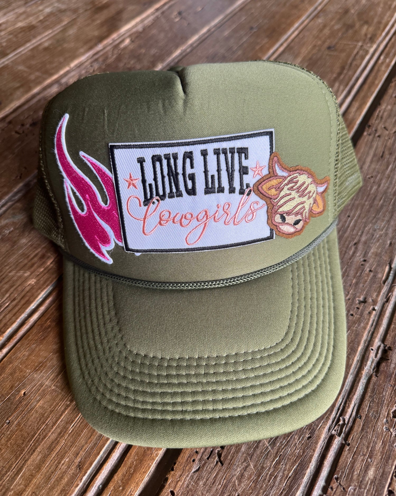 Green trucker hat with patches on a wooden surface