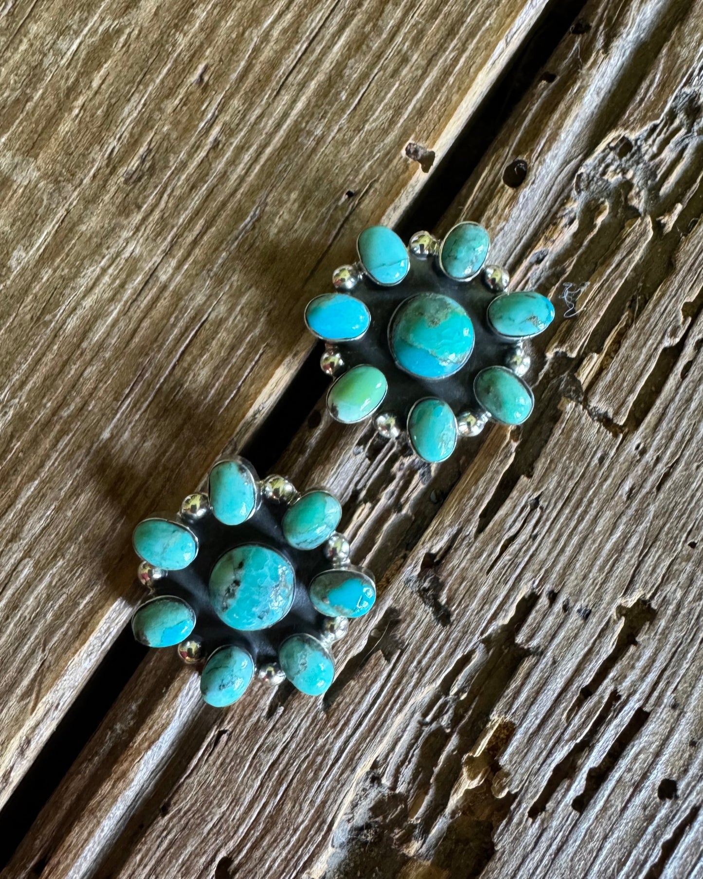 Turquoise stone earrings on a wooden surface