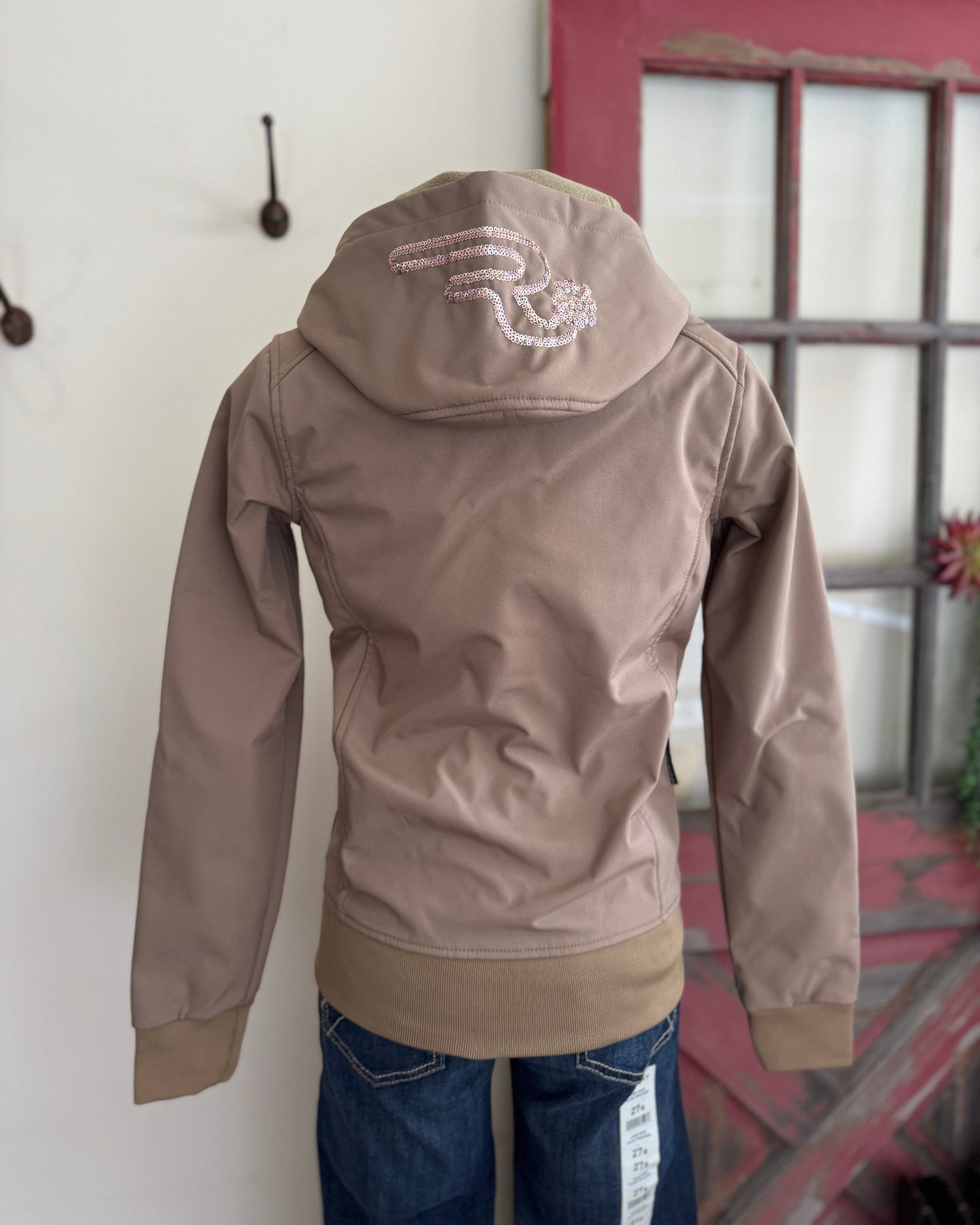 Brown jacket with a logo on the back, on a mannequin against a white wall.
