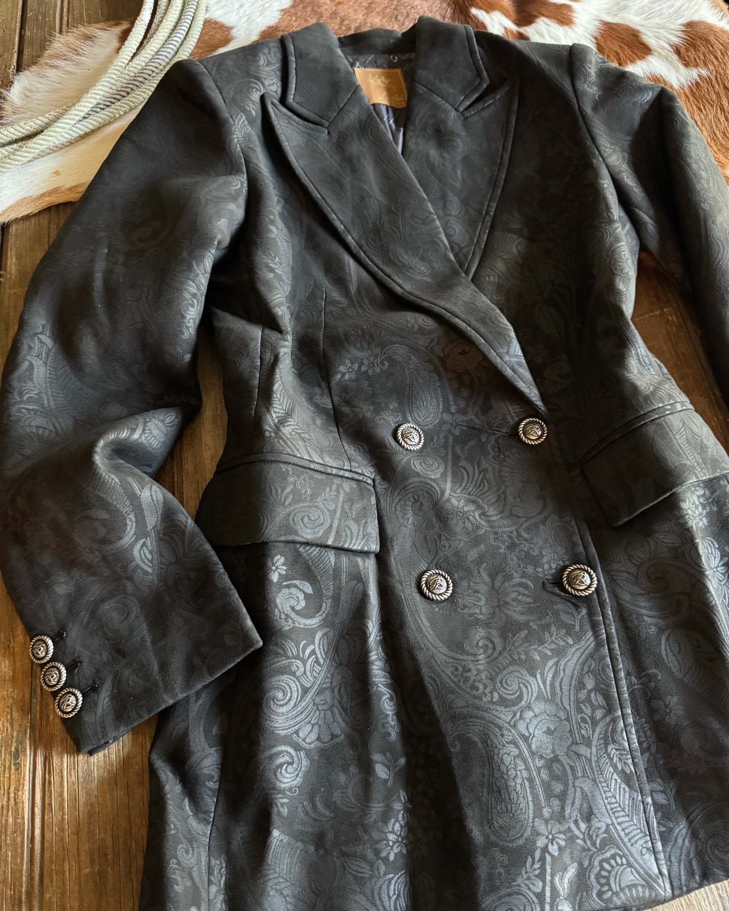Dark jacket with paisley pattern on a wooden surface