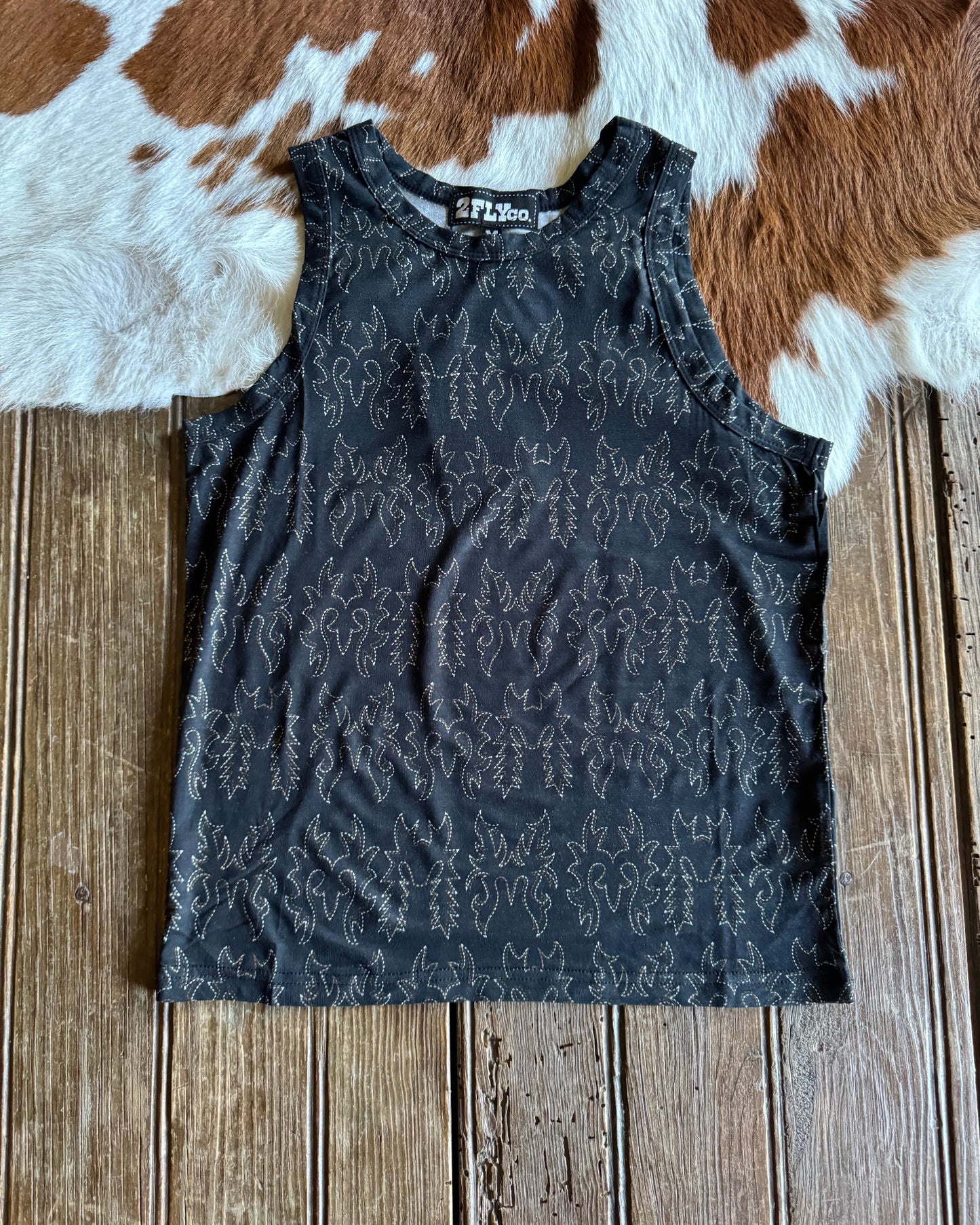 Black top on a wooden surface with a cowhide rug