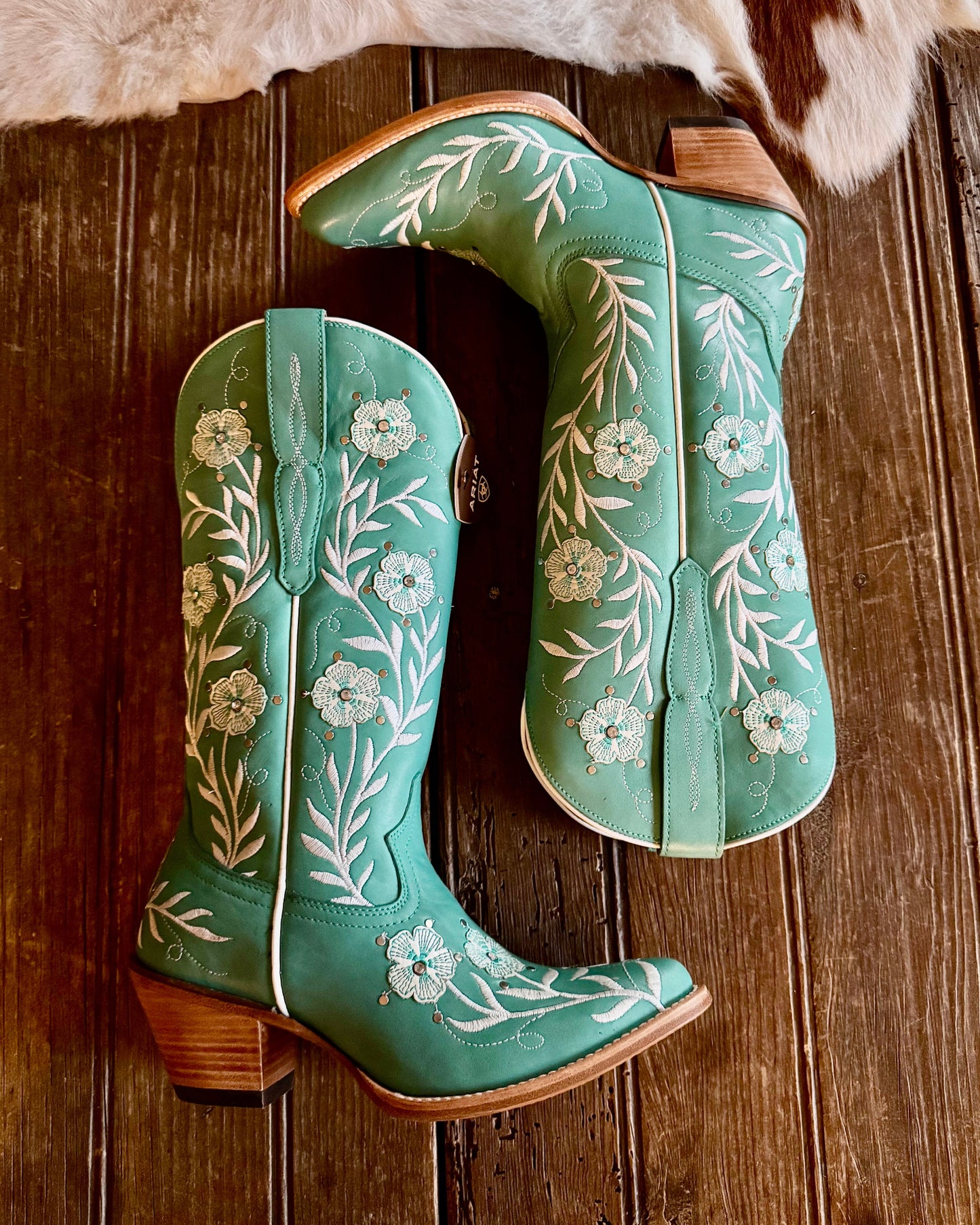 Turquoise Floral Embroidered boots on rustic wood background