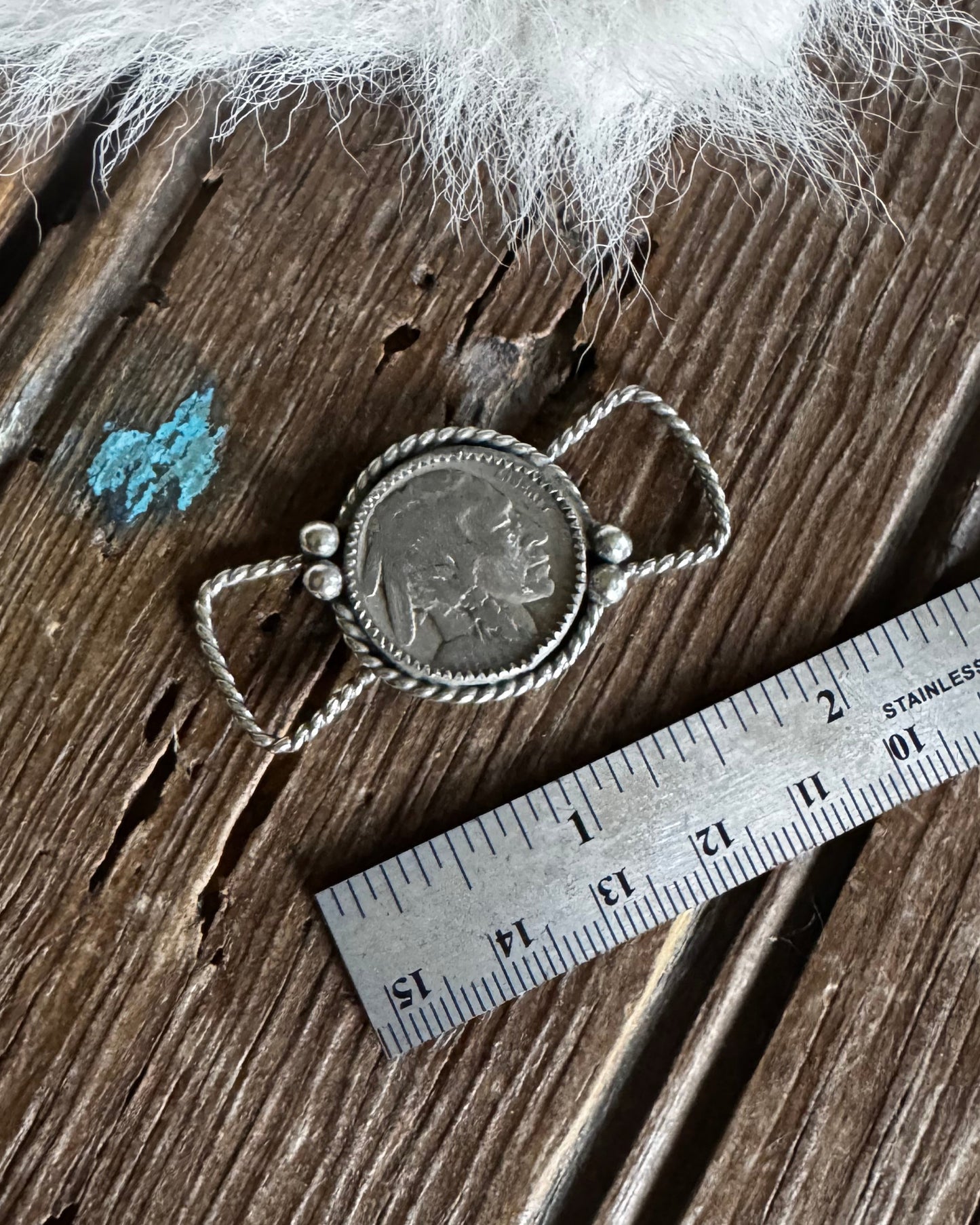 Decorative twilly slide on a wooden surface with a ruler for scale