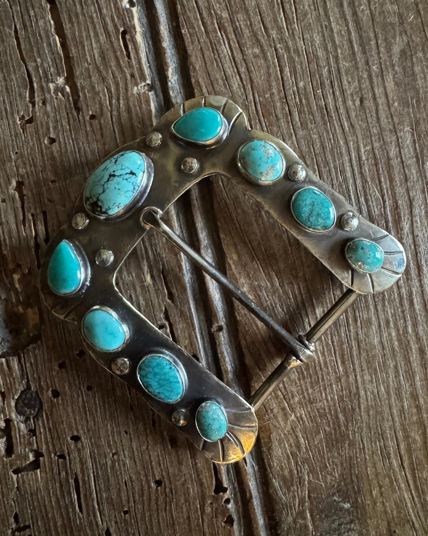 Horse shoe buckle 9 with turquoise on rustic wood background