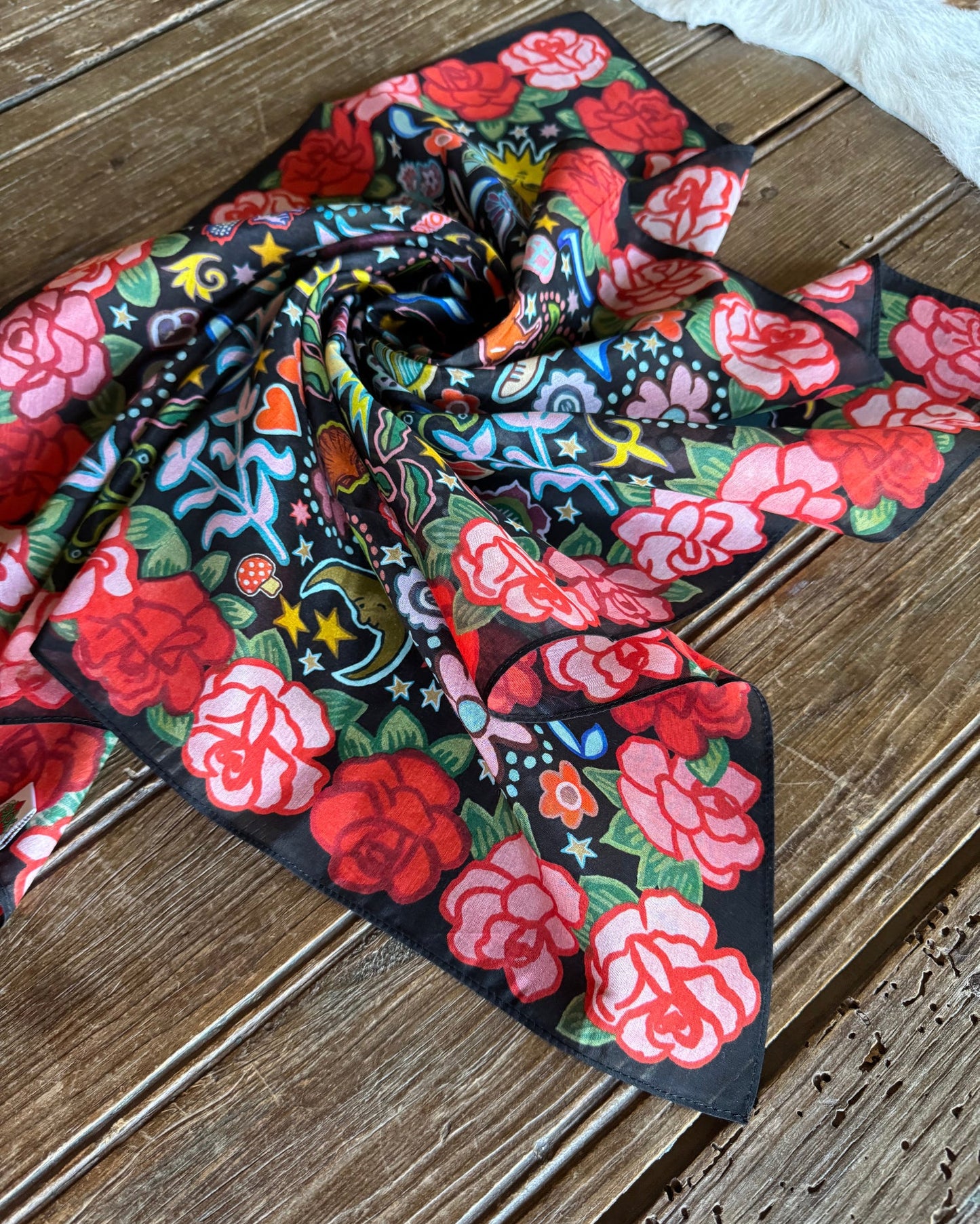 Rose Ranch Shorty Scarf folded on rustic wood background
