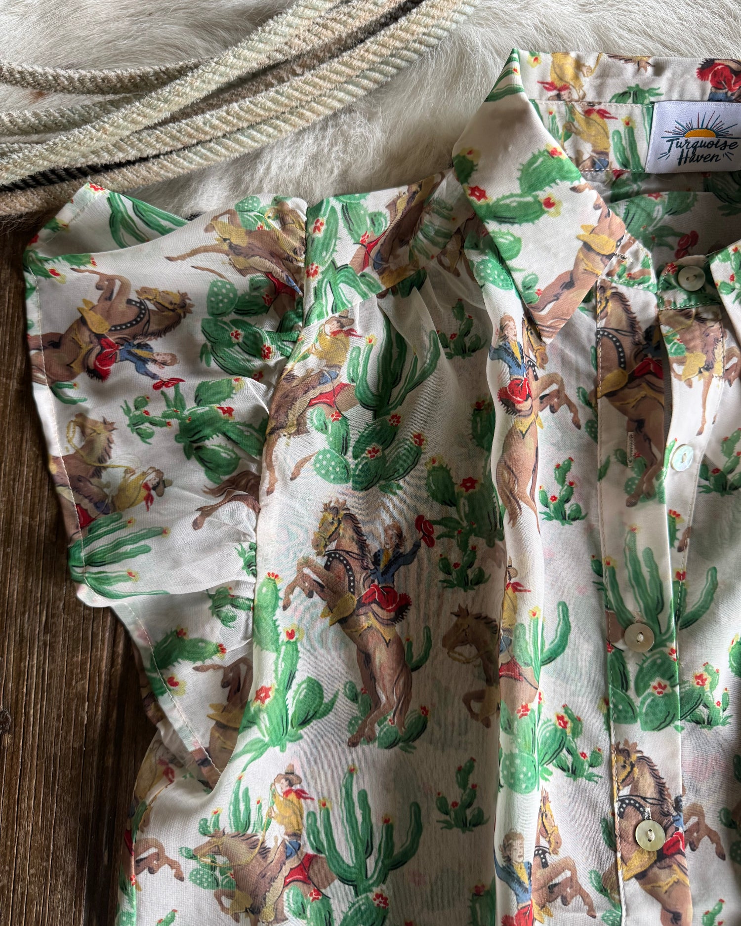 Fabric with a cactus and animal pattern on a wooden surface