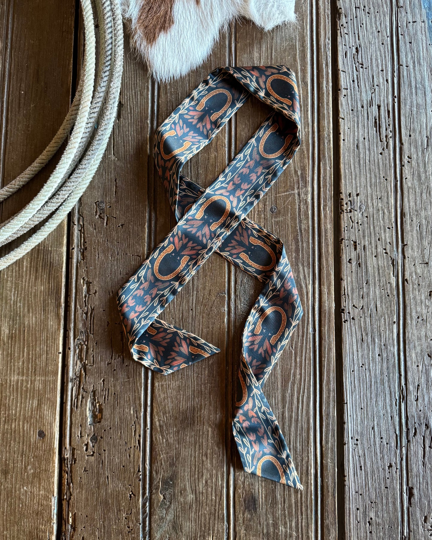 Horseshoe ribbon scarf on a rustic background with a rope