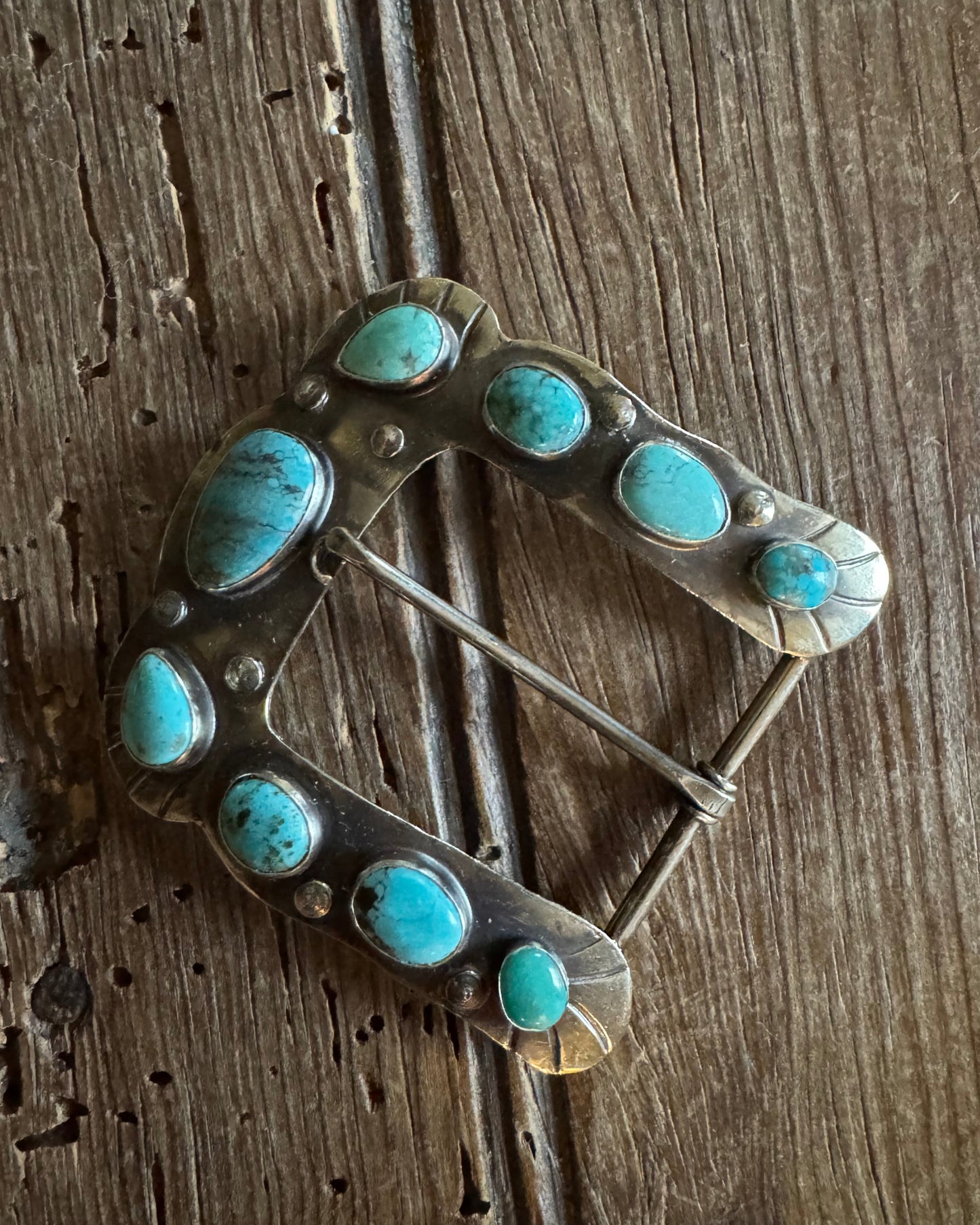 Horse shoe buckle 6 with turquoise on rustic wood background