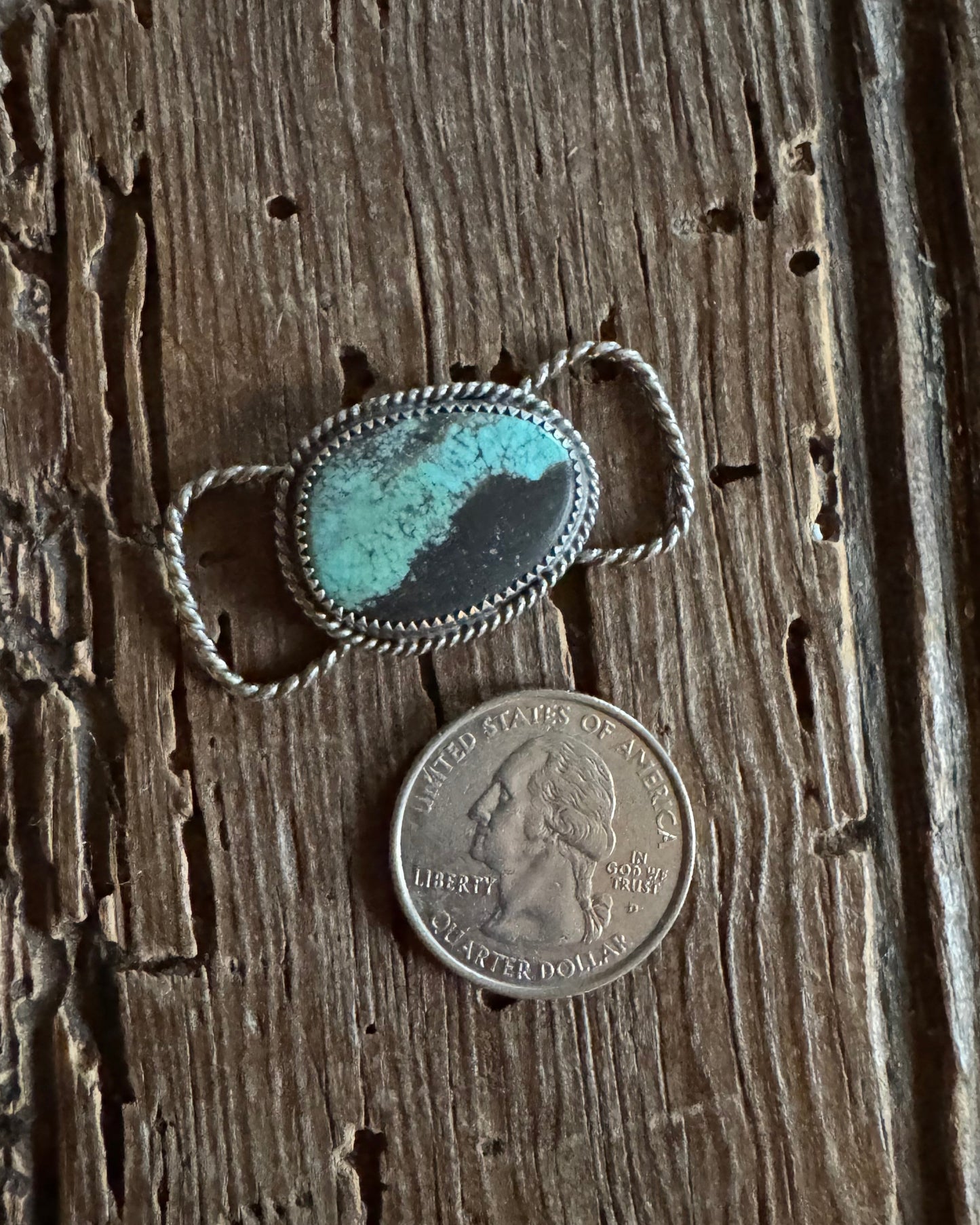 Turquoise stone twilly slide on a wooden surface with a coin for scale