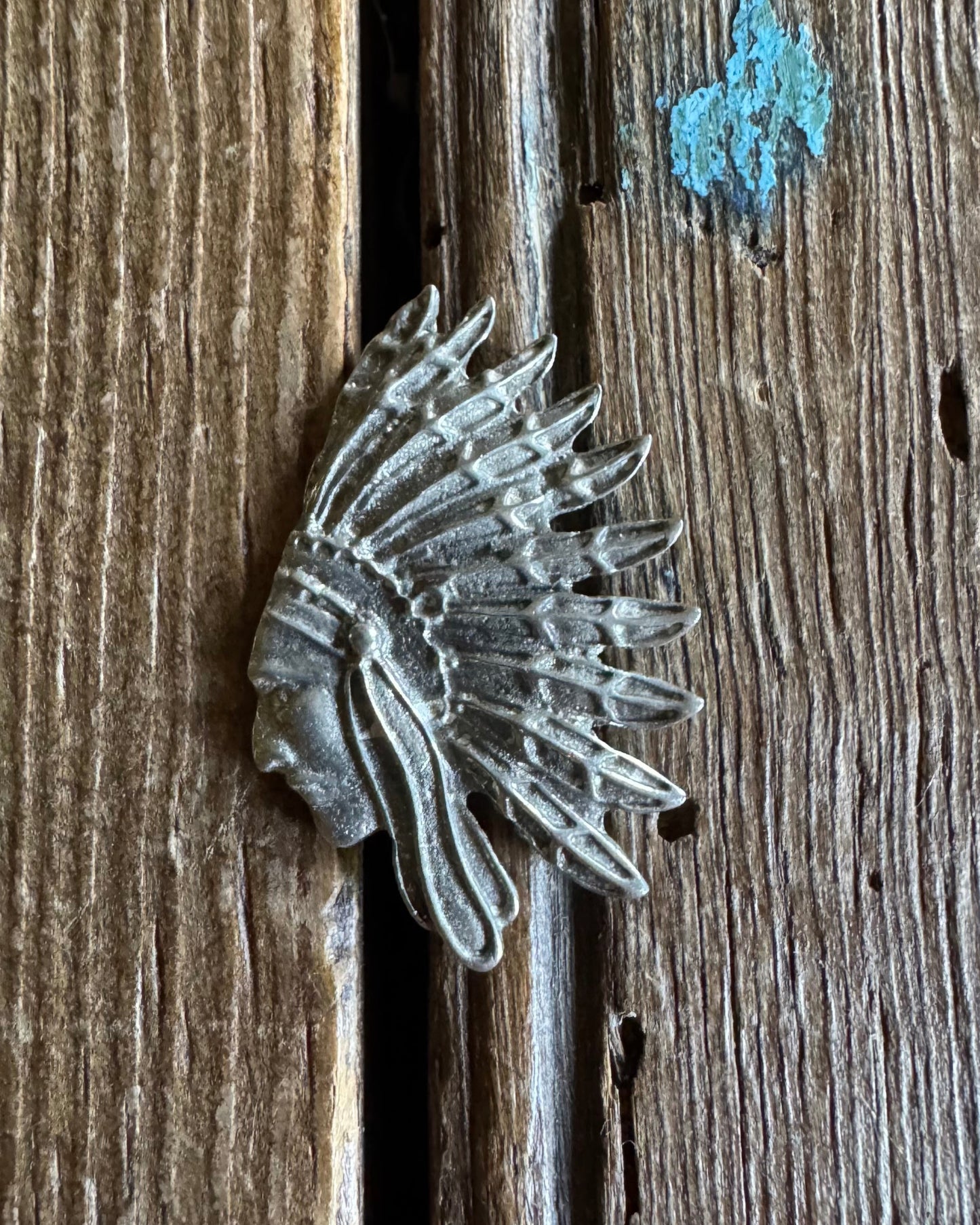 Metallic headdress-shaped object on a wooden surface