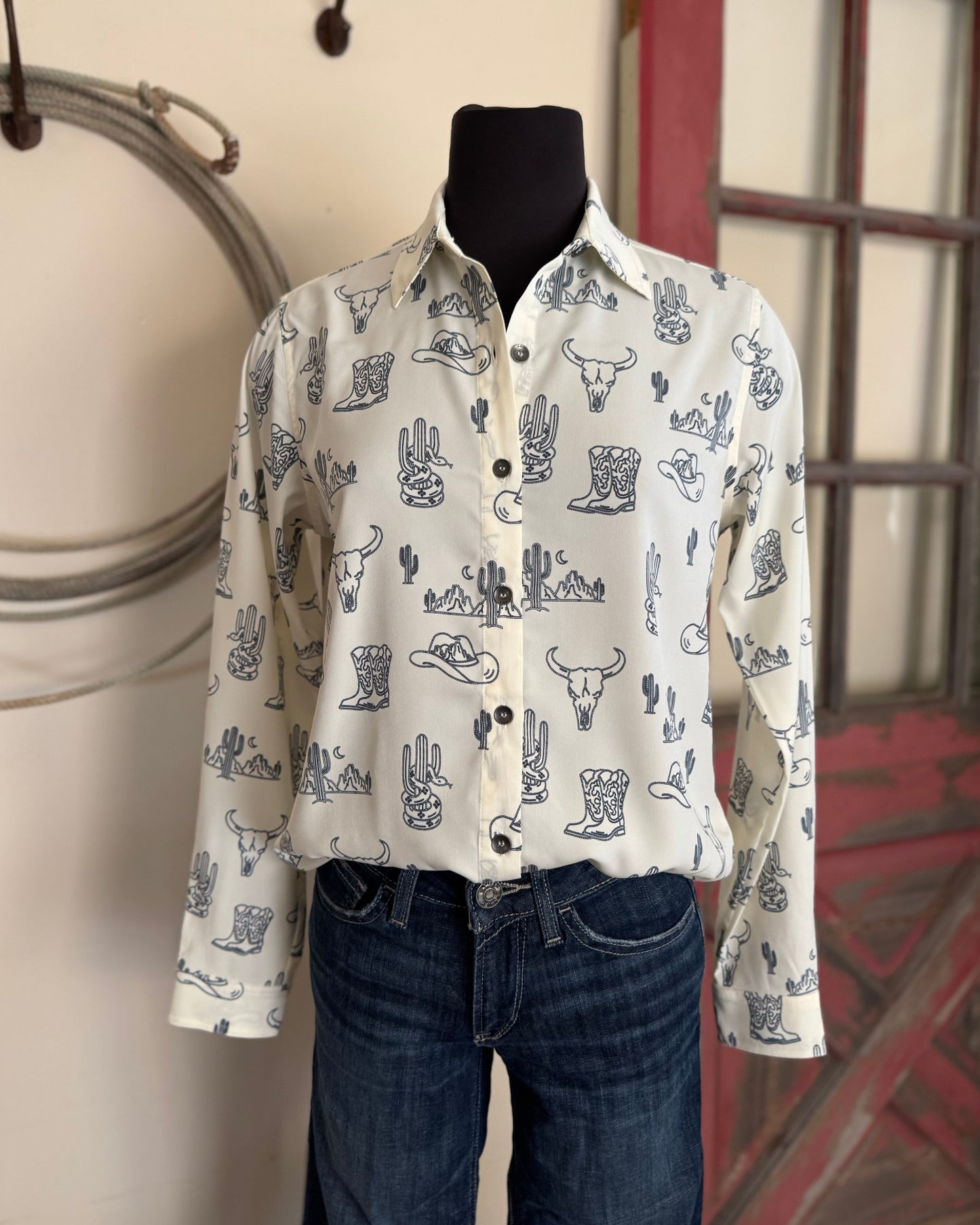 White shirt with blue patterns on a mannequin against a neutral background