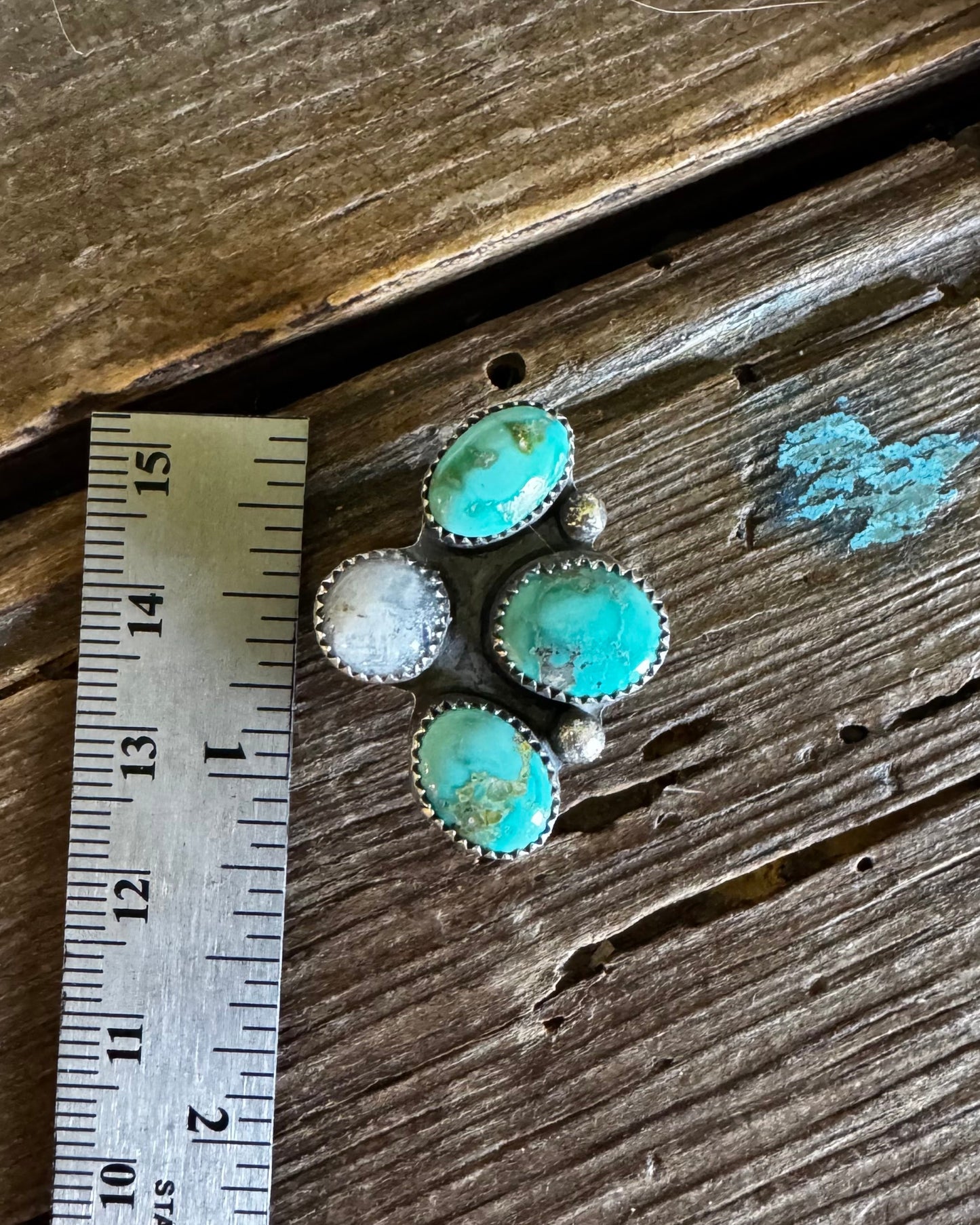 Turquoise hat slide on a wooden surface with a ruler for scale.