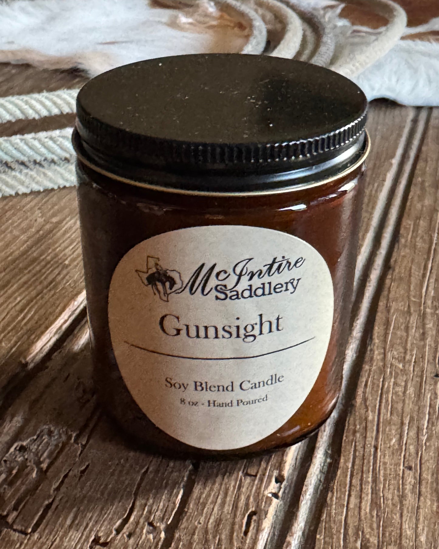 Candle jar with a label on a wooden surface