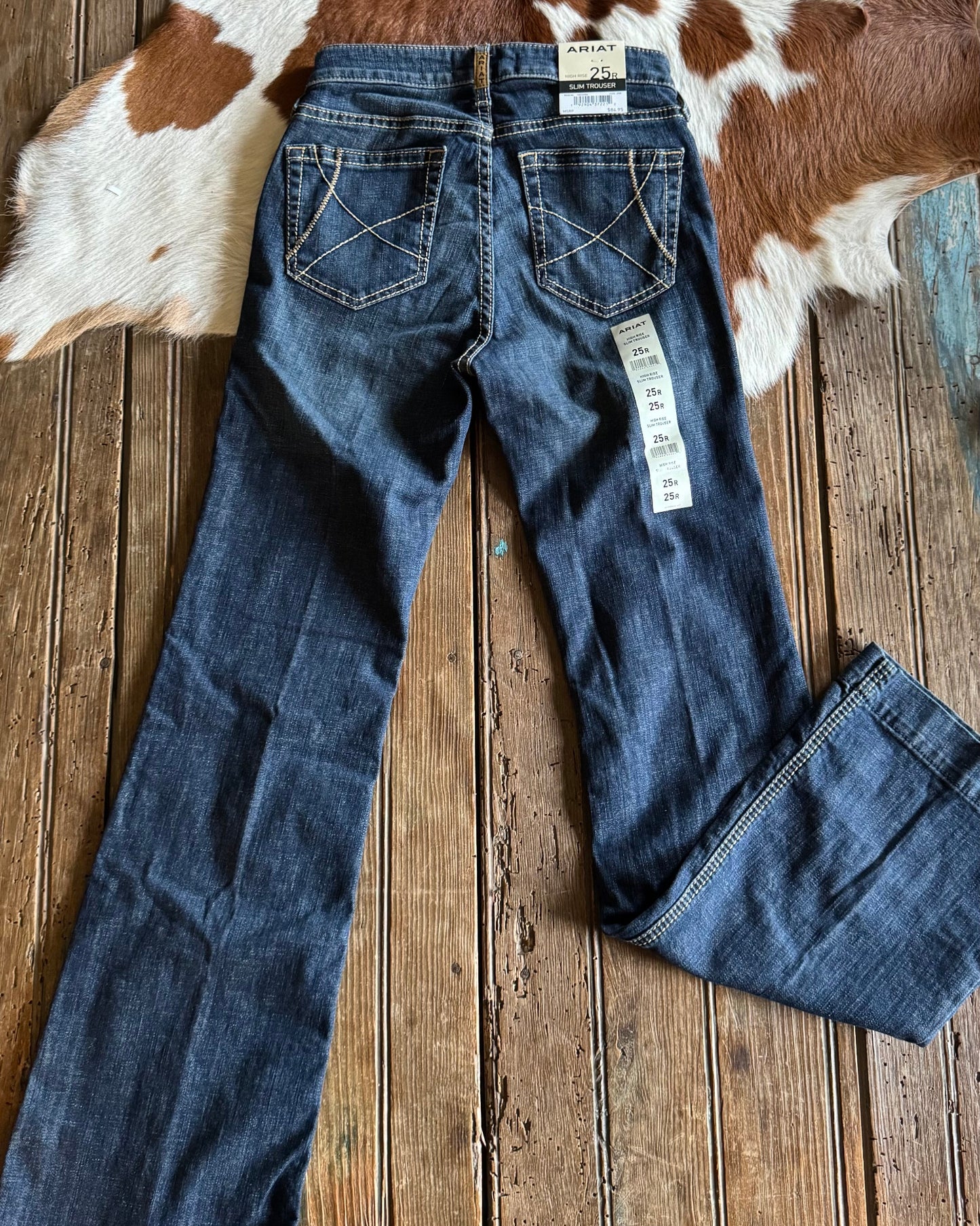 back view of Ella High Rise Slim Trouser Jeans on rustic wood background