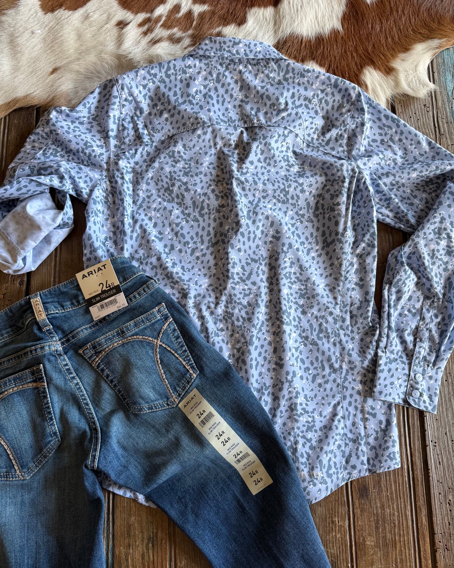 back of blue leopard button up shirt with jeans on rustic wood background