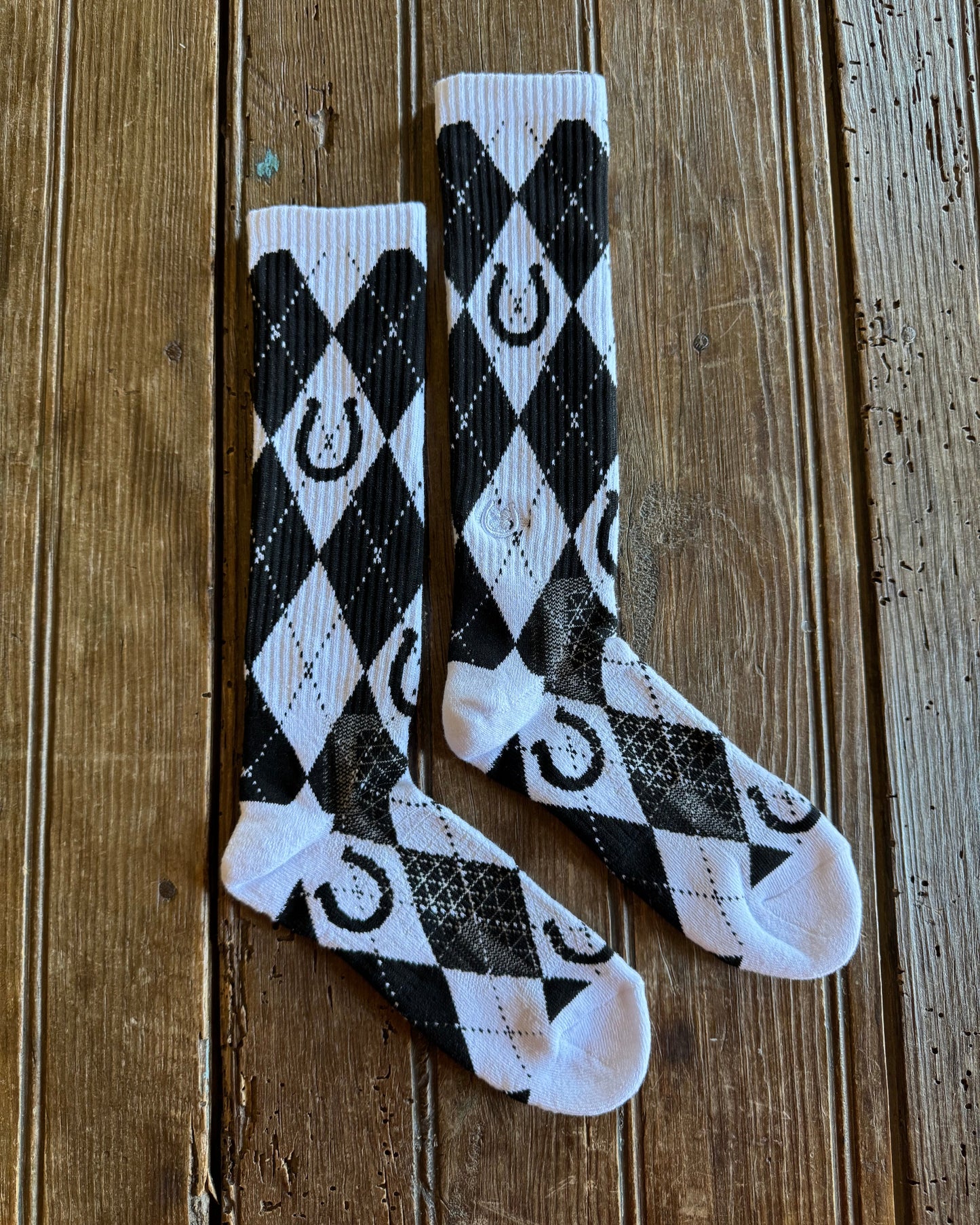 Lucky Argyle Black & White Performance Socks on rustic wood background