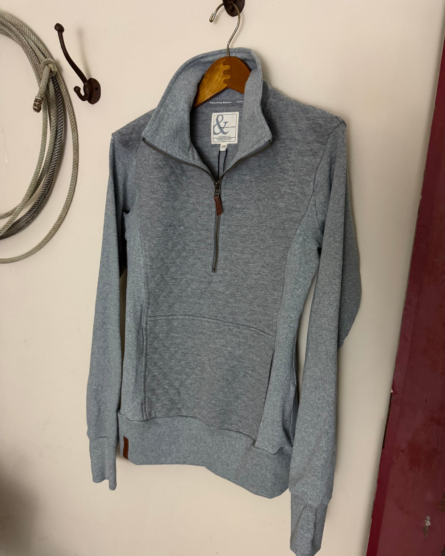 Gray hoodie with a brand tag on a light-colored surface