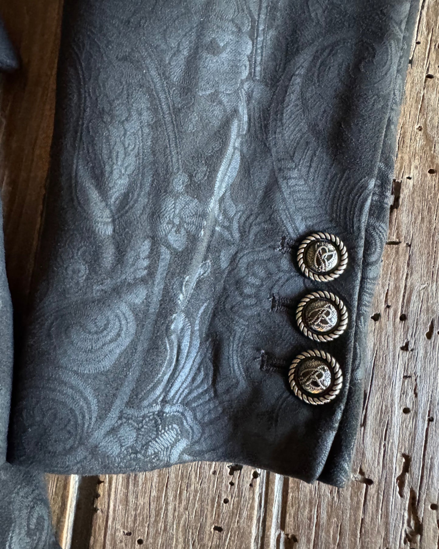black fabric with decorative buttons on a wooden surface