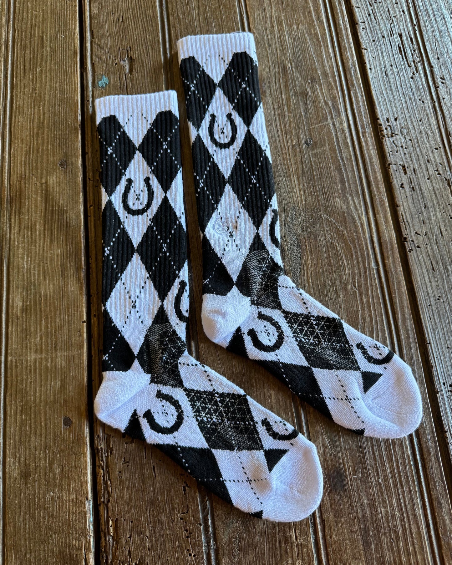 Lucky Argyle Black & White Performance Socks on rustic wood background
