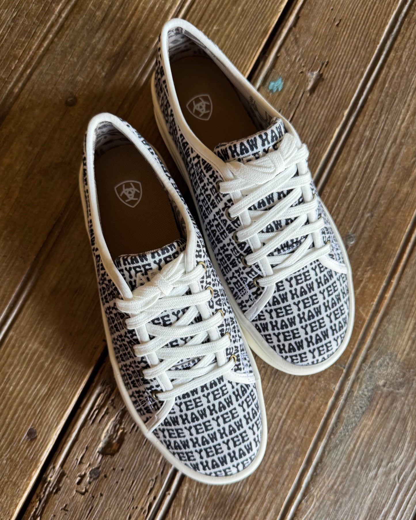 top view of yeehaw printed sneakers on rustic wood background
