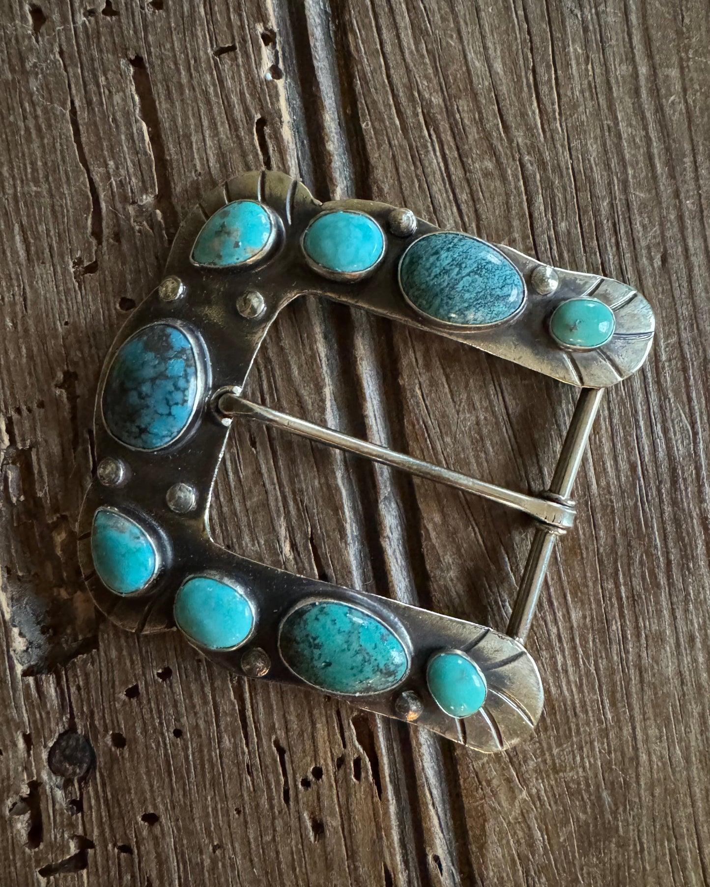 Horse shoe buckle 3 with turquoise on rustic wood background