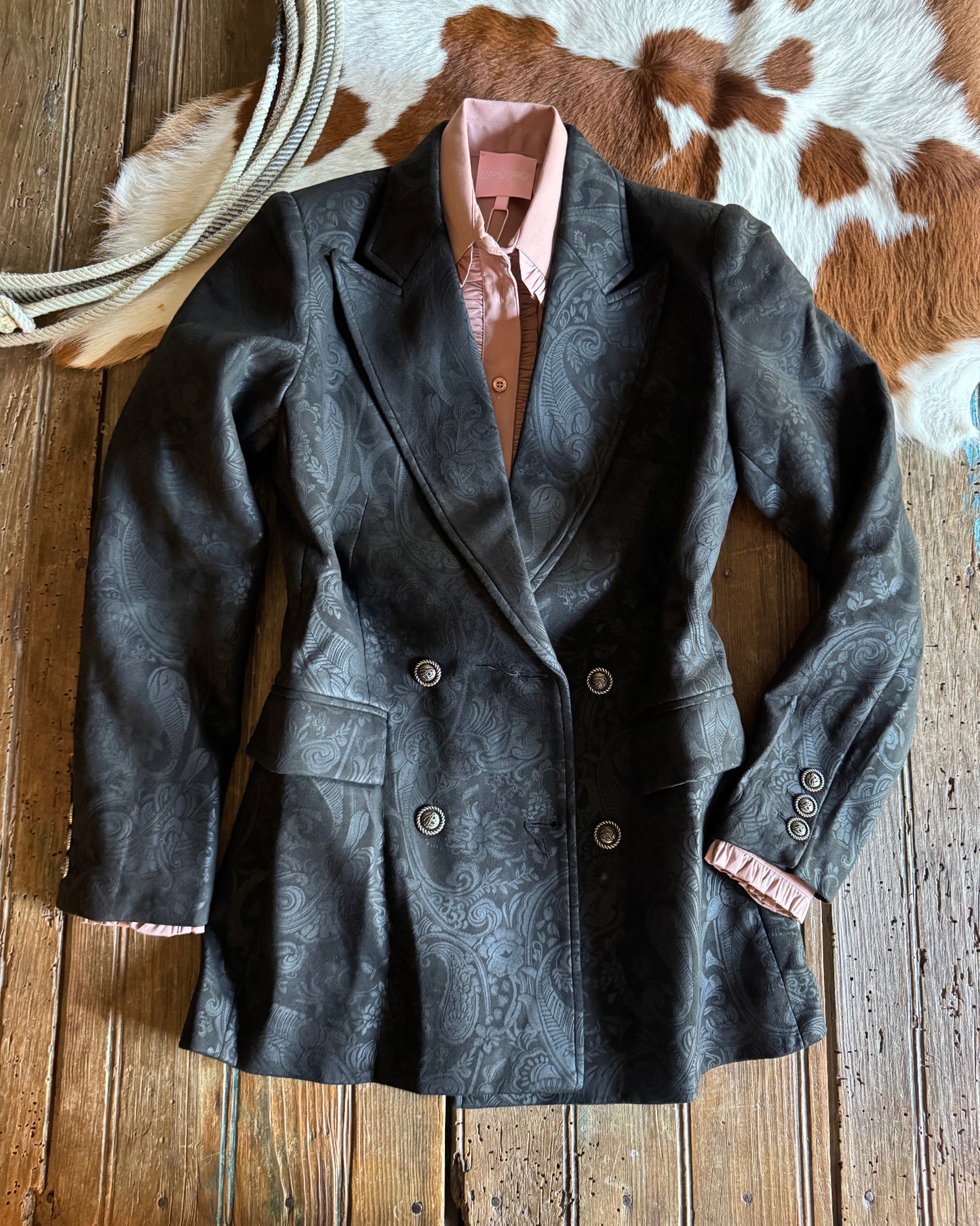 Dark jacket with button details on a wooden surface