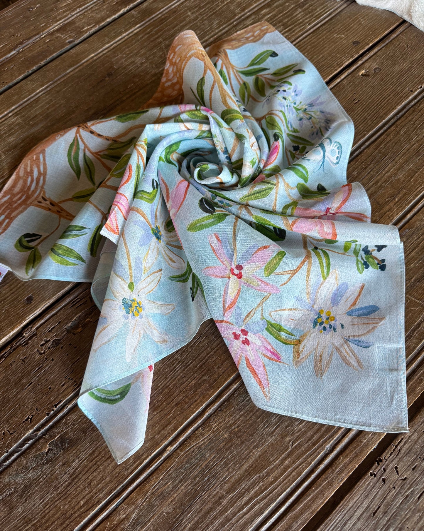 Garden Party Shorty Scarf folded on rustic wood backgound