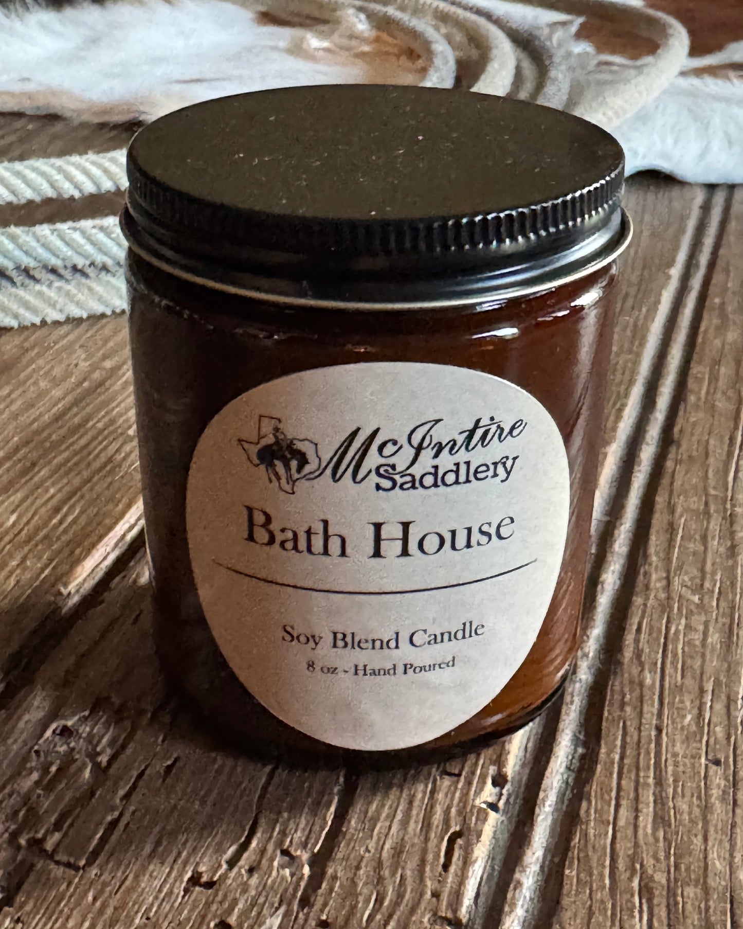 Candle jar with a label on a wooden surface