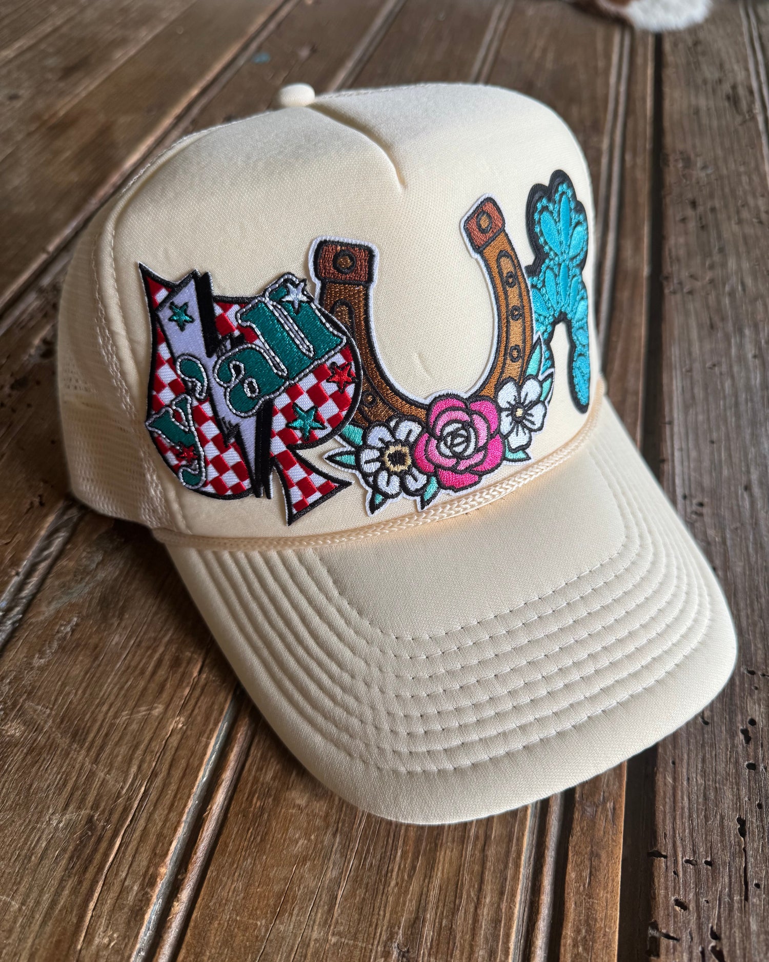 Beige cap with colorful designs on a wooden surface