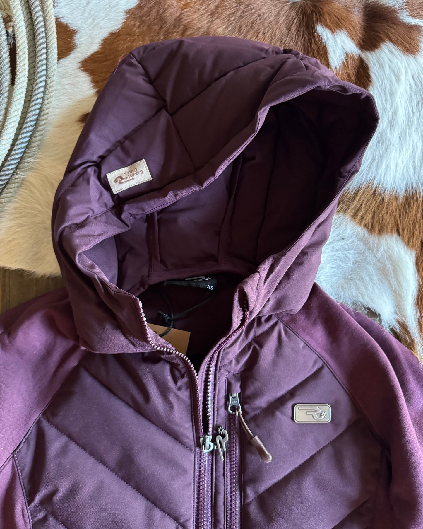 Purple jacket with a brand logo on a patterned surface