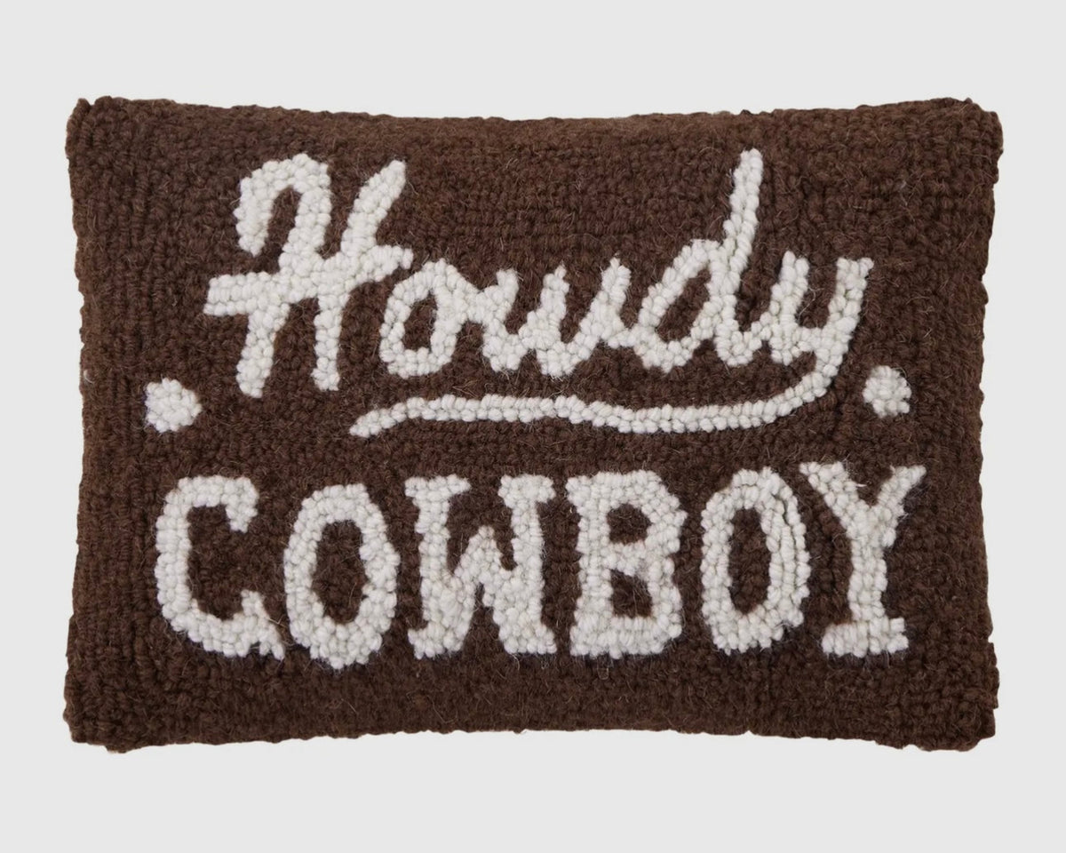 Textile pillow with 'Howdy Cowboy' text on a brown background