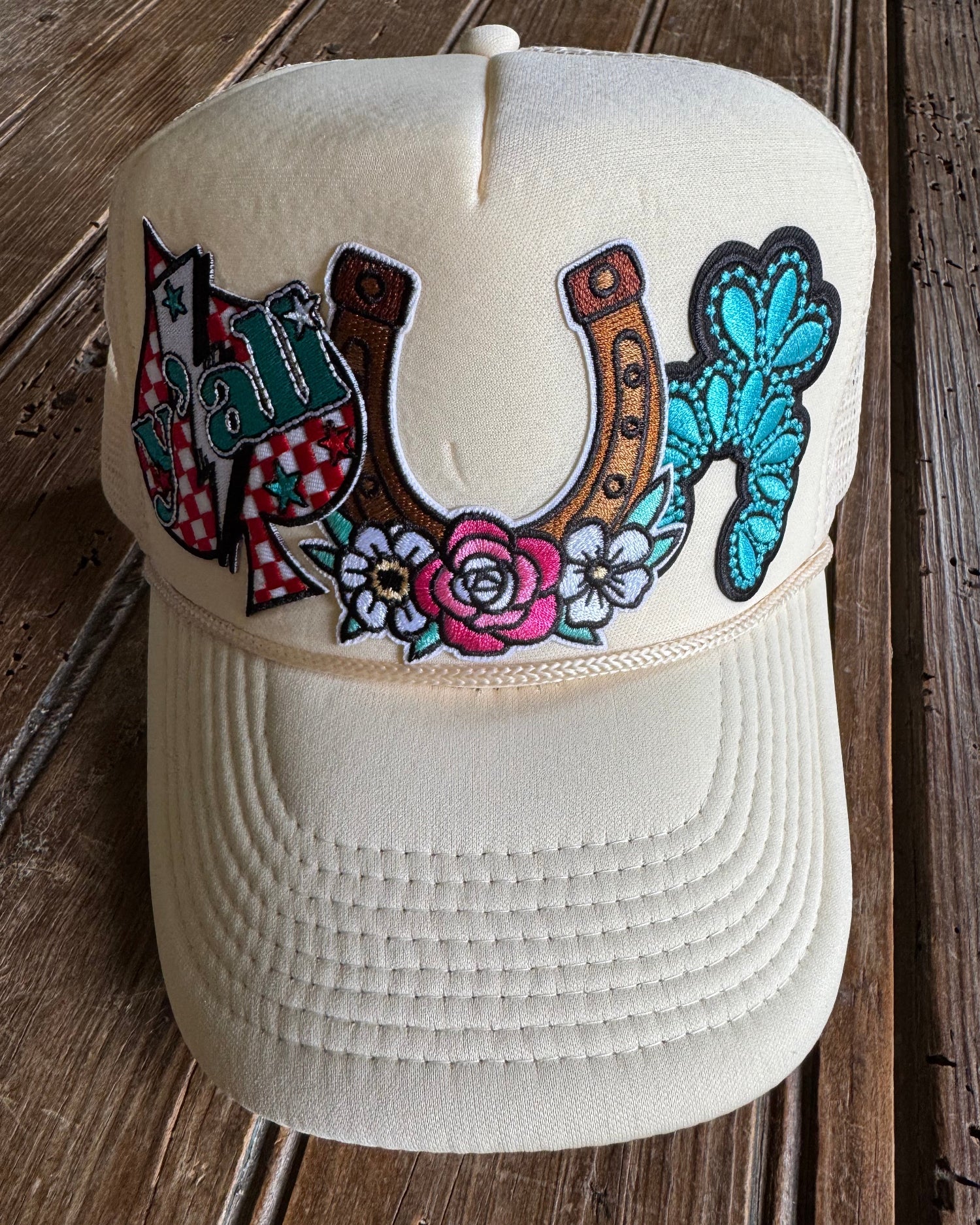 cream foam trucker hat with patches on wooden surface