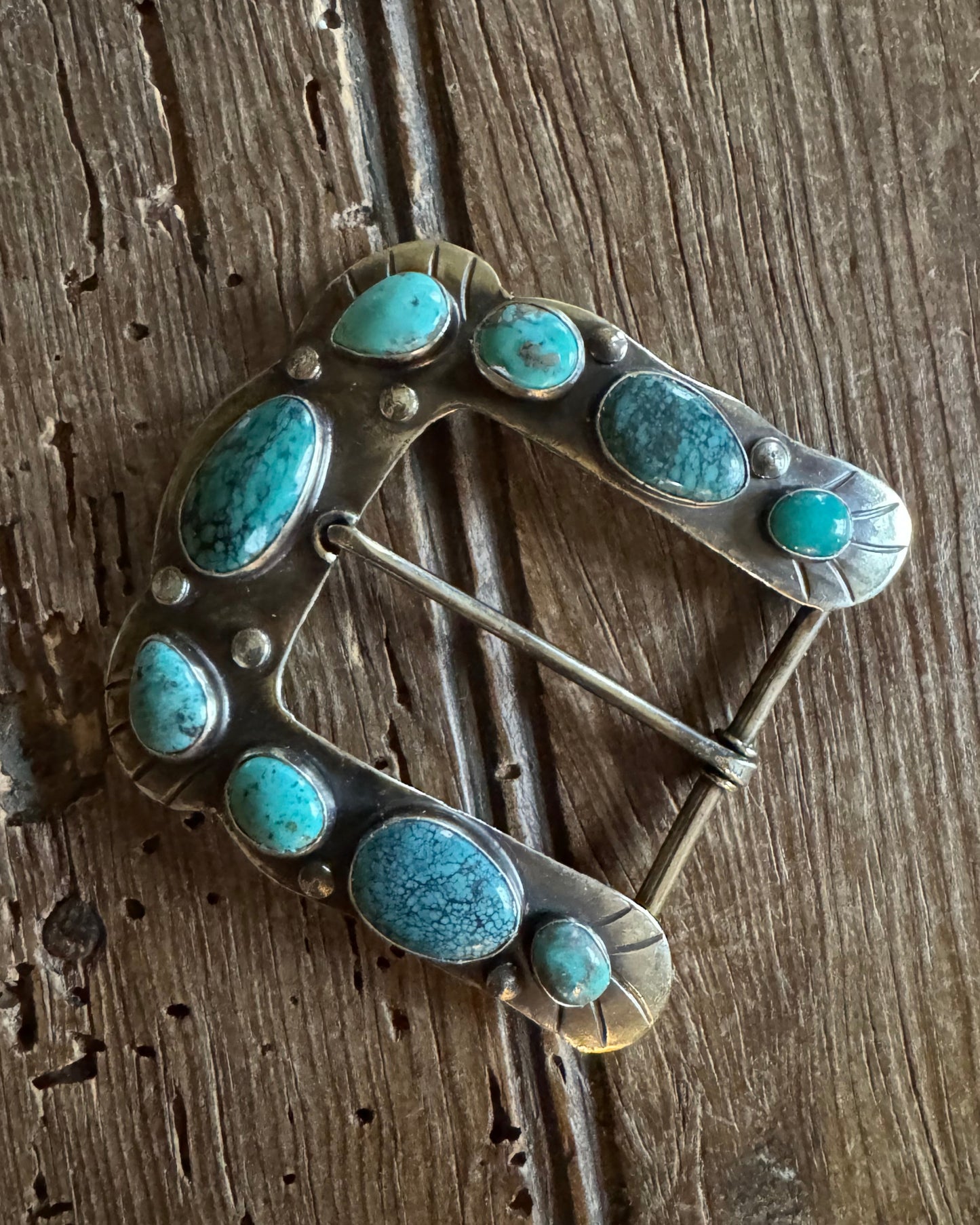 Horse shoe buckle 4 with turquoise on rustic wood background