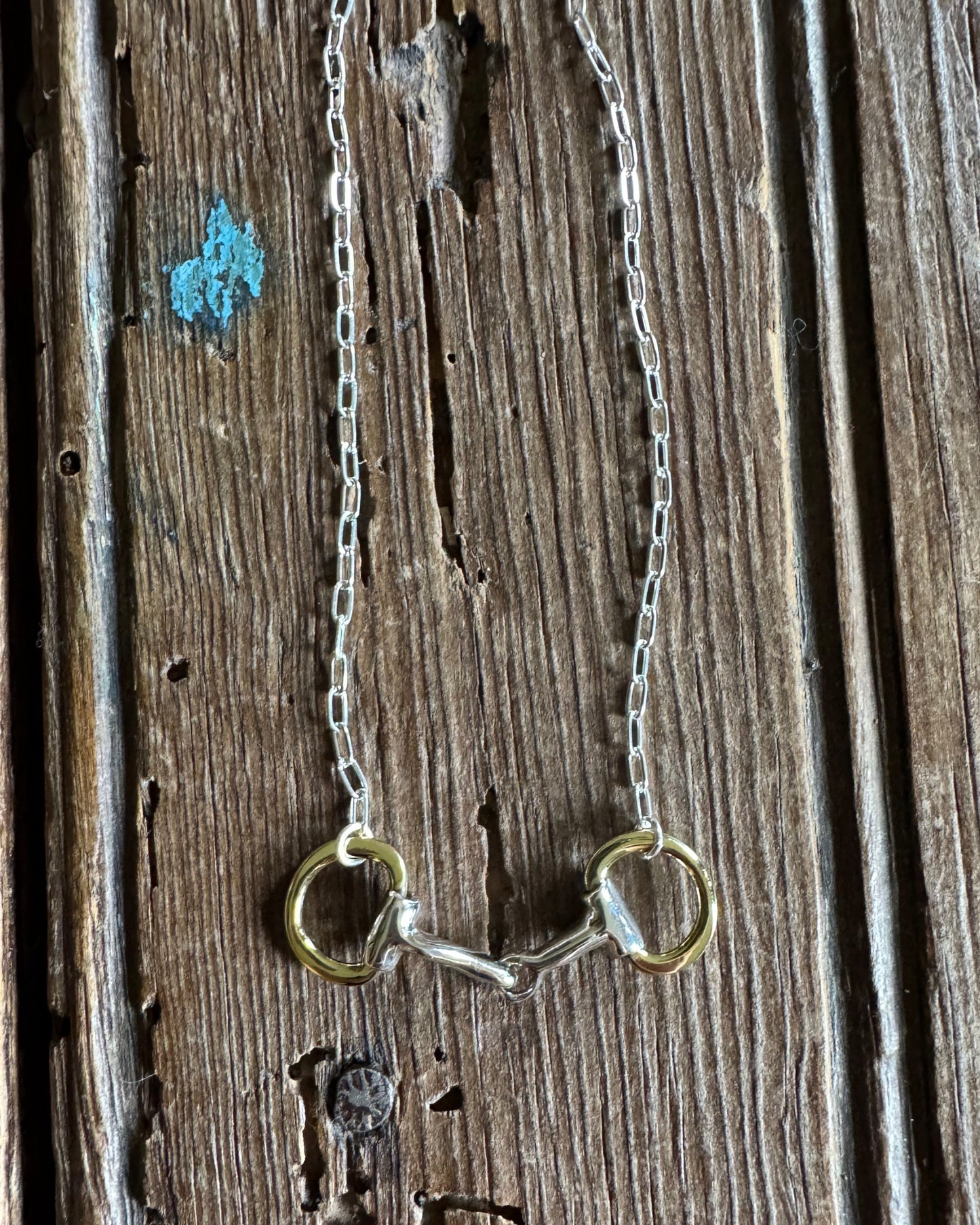 Briarwood Snaffle Bit Necklace on rustic wood background
