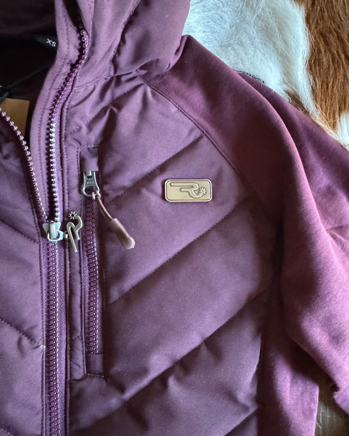 Purple jacket with a brand logo on a neutral background