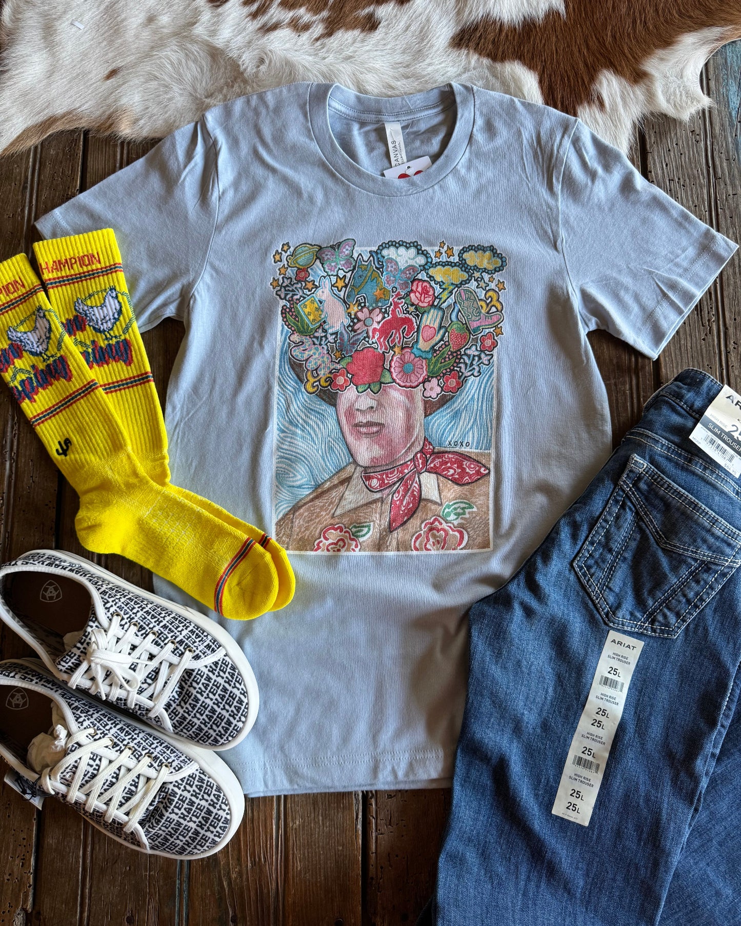 graphic tee with shoes, socks and jeans on rustic wood background