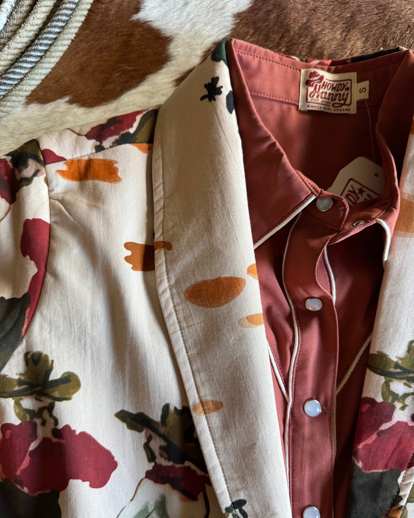 Folded clothing items with floral patterns on a textured surface