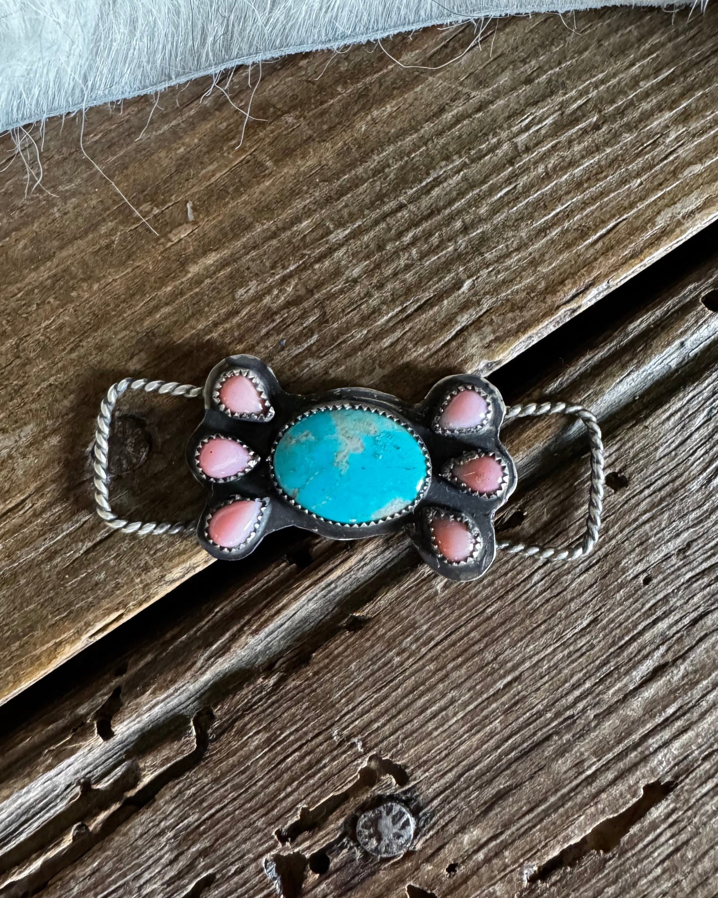 Pink conch and turquoise twilly slide on rustic wooden background