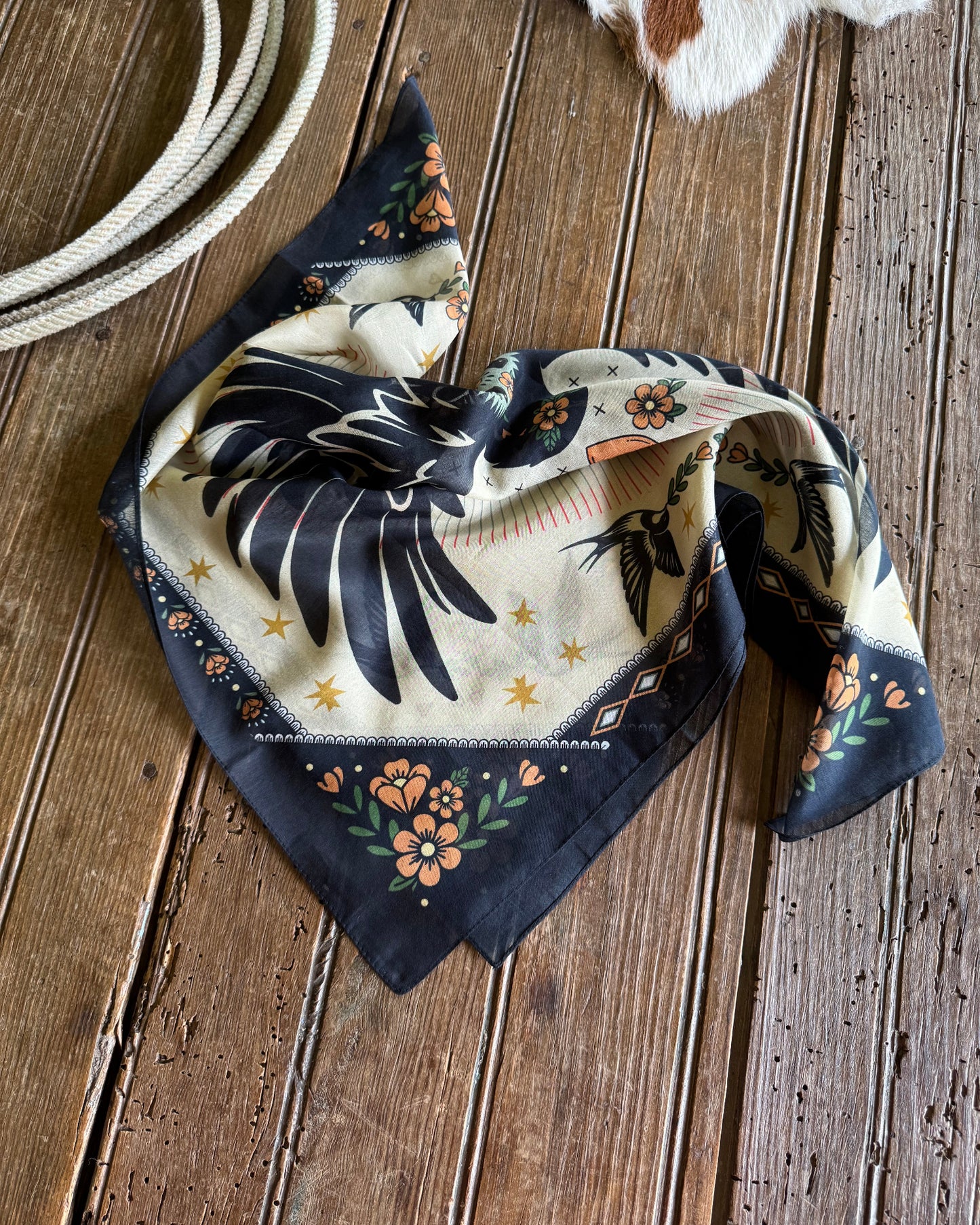 Decorative scarf with dove design on a wooden surface