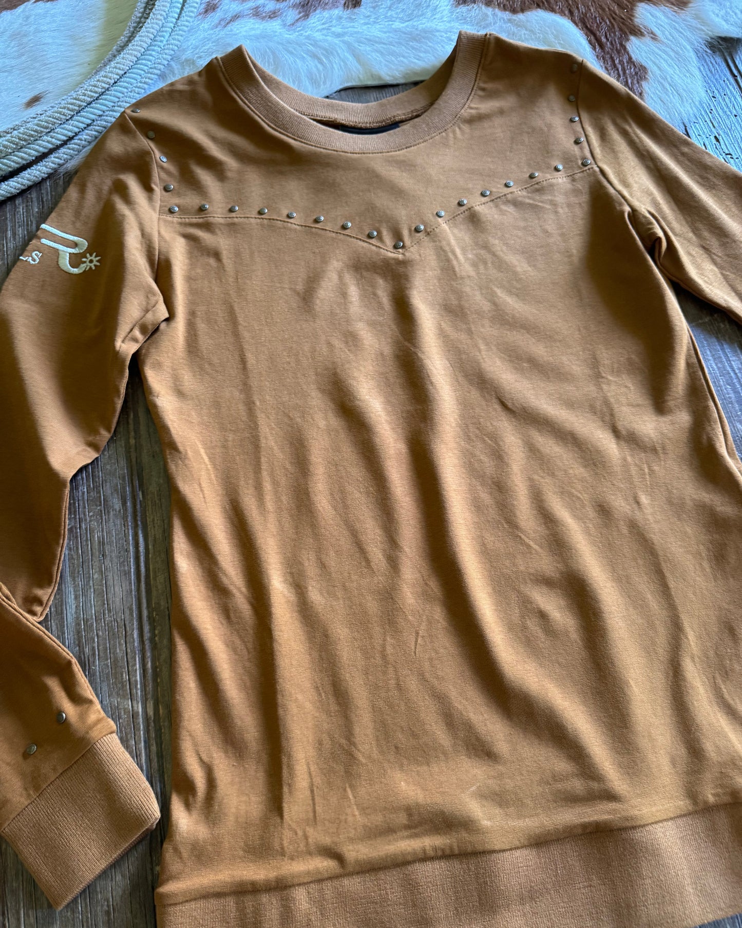 Brown shirt with button details on a wooden surface
