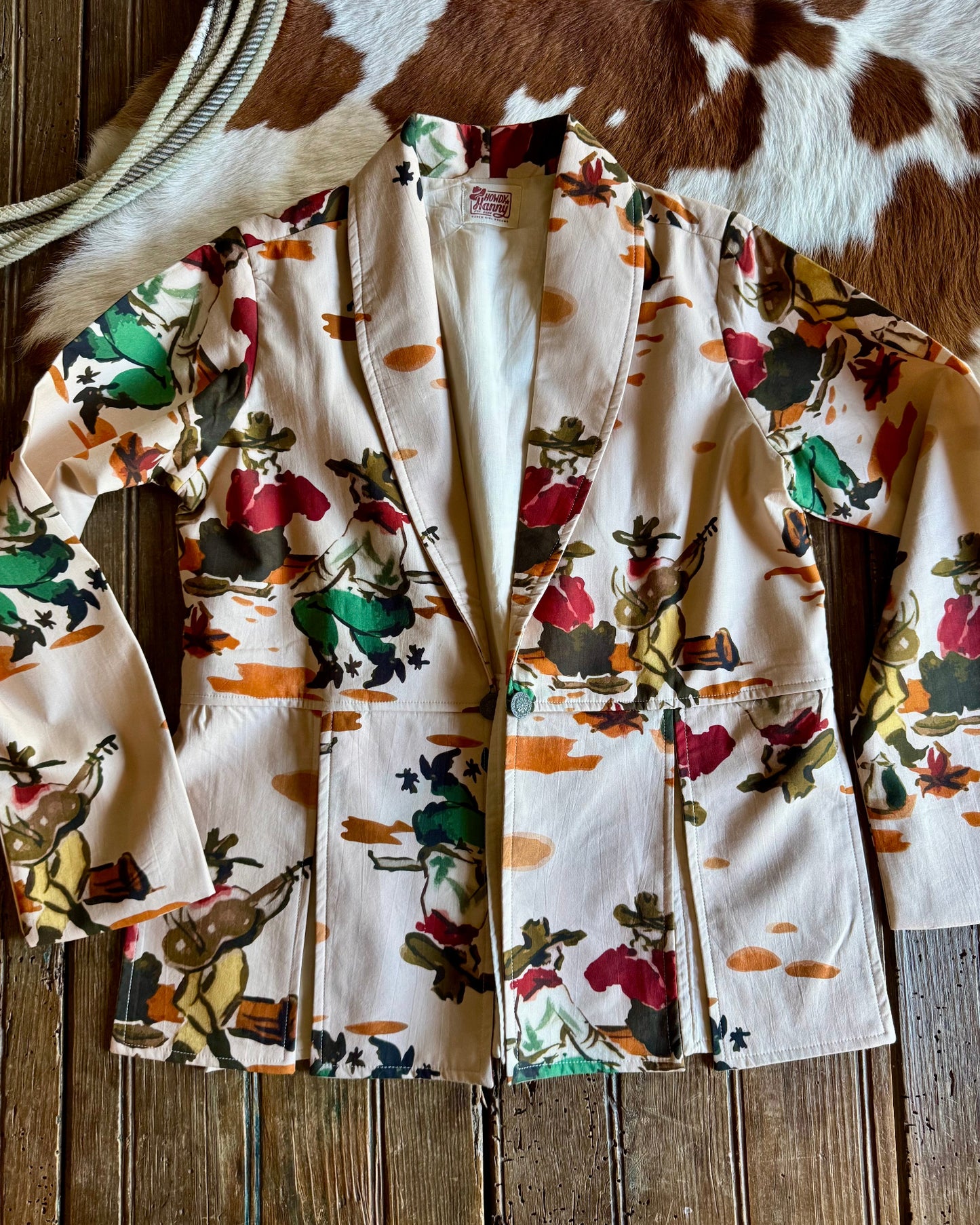 Floral-patterned jacket on a wooden surface with a cowhide rug in the background