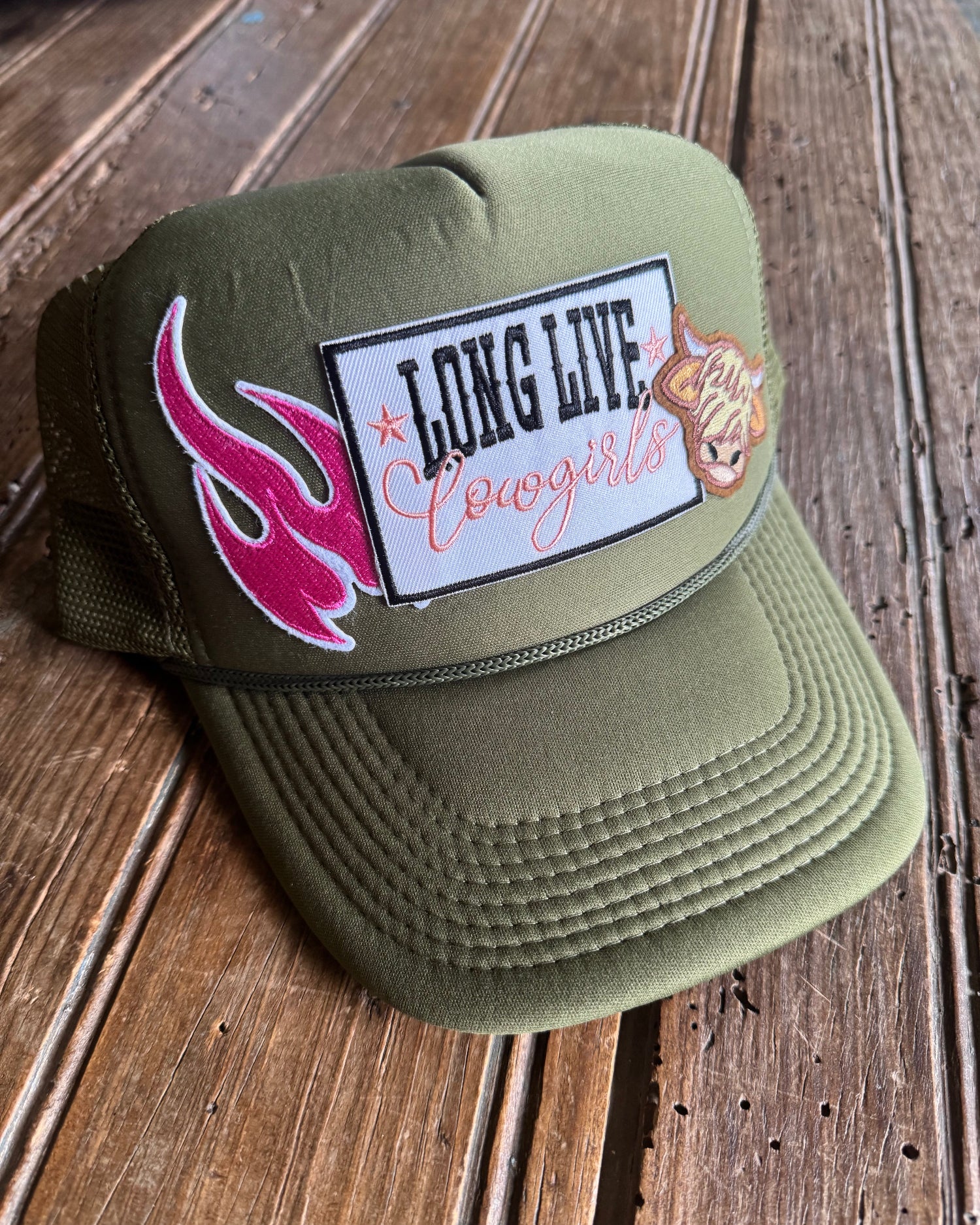 Green foam trucker cap with a patch on a wooden surface