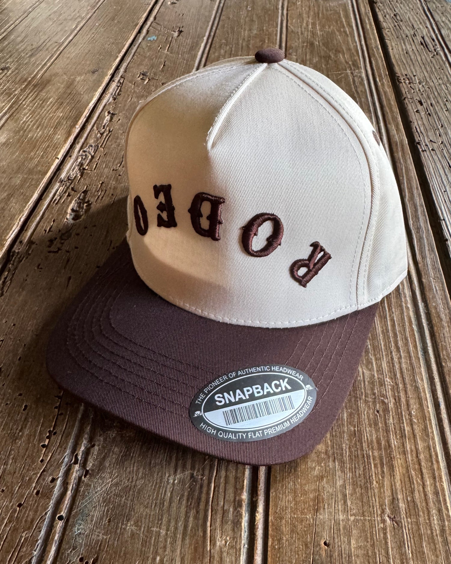 Baseball cap with 'RODEO' on a wooden surface