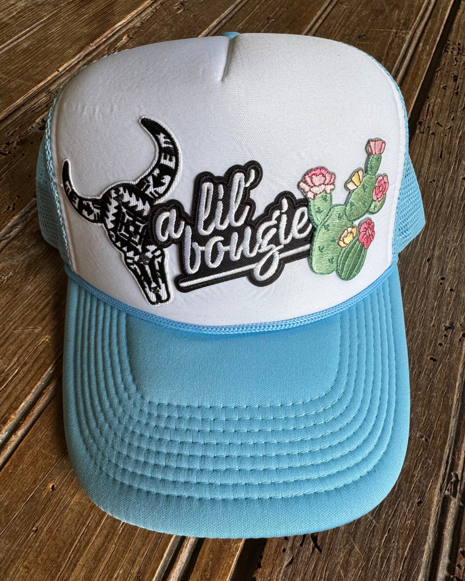 blue and white foam trucker hat featuring a cactus design on a wooden surface