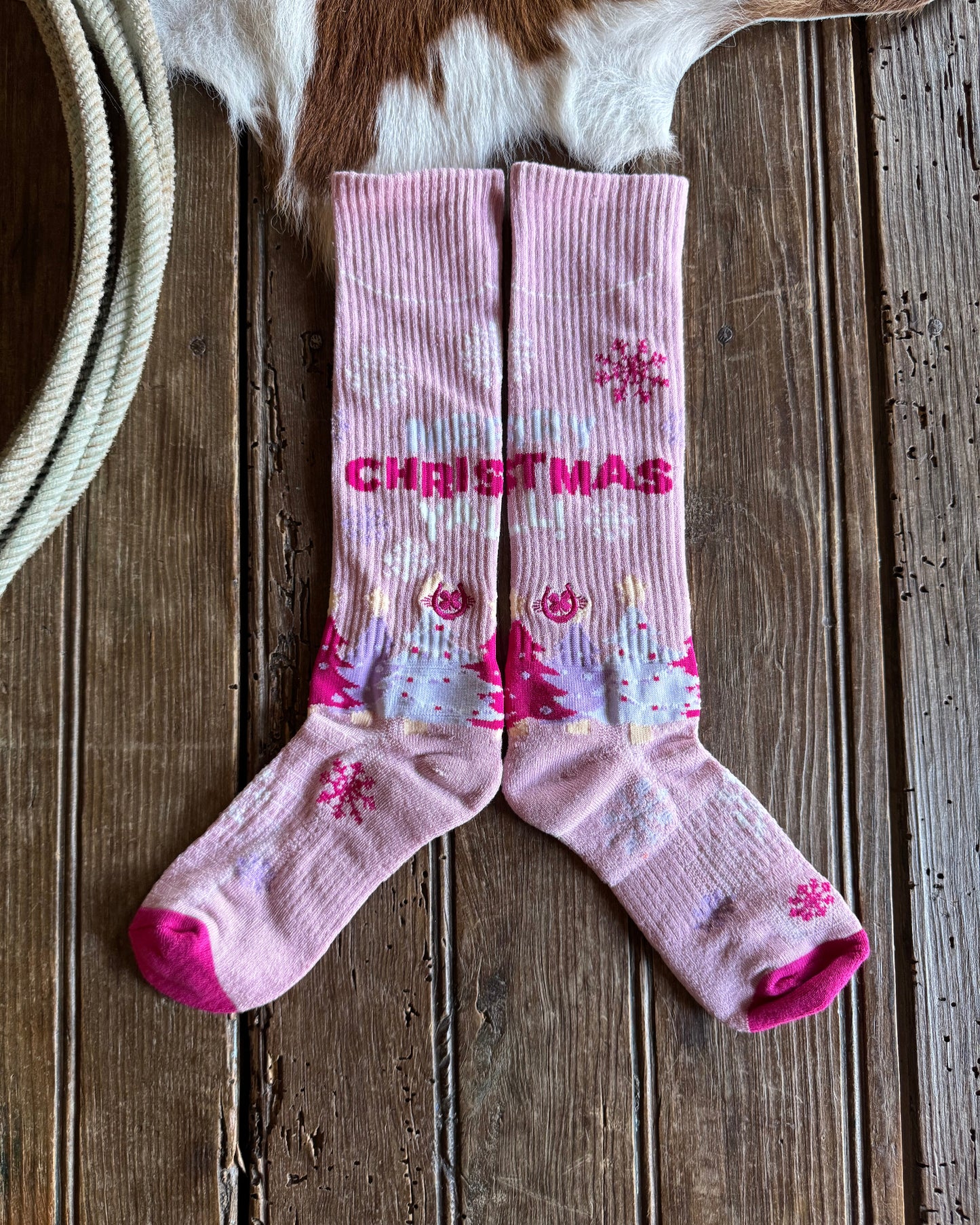 Pair of pink socks with floral patterns on a wooden surface