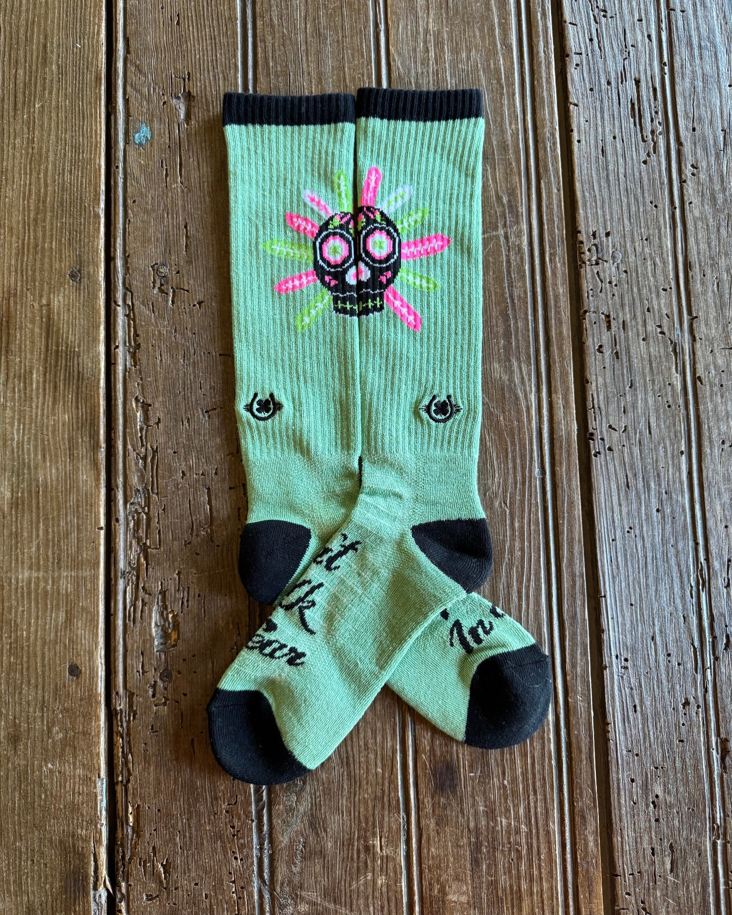 Don't Walk In Fear Performance Socks (Sage) showing design on rustic wood background
