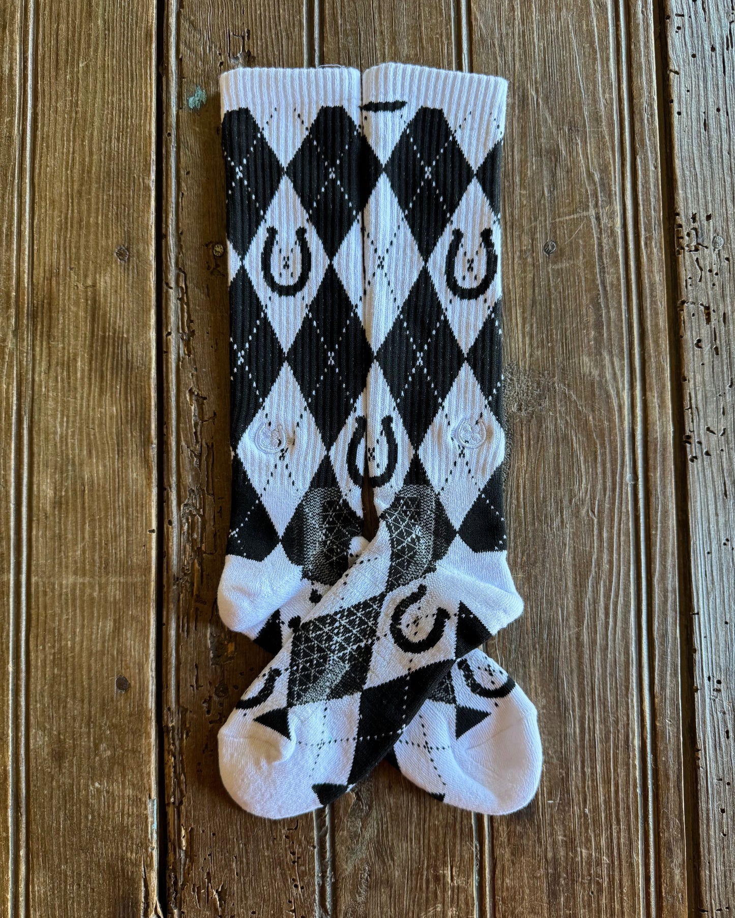 Lucky Argyle Black & White Performance Socks showing design on rustic wood background